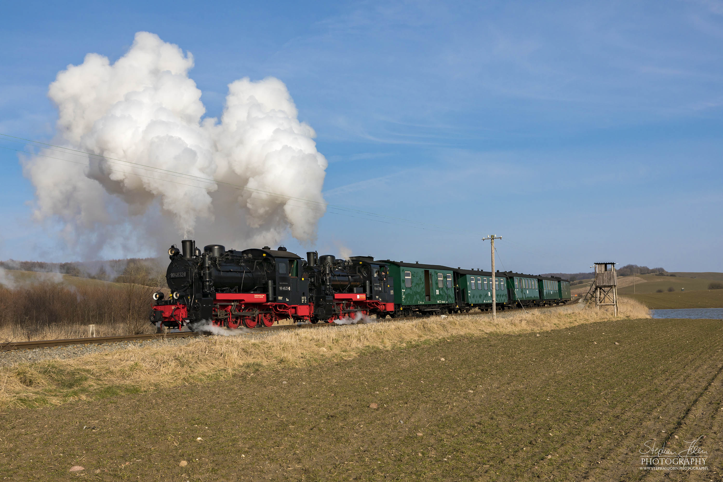 Seit der Hauptuntersuchung im Januar 2018 hat die Rügen-Lok 99 4632-8 (Vulcan-Lok) wieder eine schwarze Reichsbahnlackierung. Die Rügen-Lok 99 4633-6 hat noch in diesem Jahr Fristablauf und kommt dann in grüner Farbgebung wieder. Beide Rügenloks in schwarzer Farbgebung ist also nur ein kurzes Vergnügen. Hier zieht die Lok 99 4633-6 mit Vorspannlok 99 4632-8 kurz nach Seelvitz einen Personenzug in Richtung Putbus. 