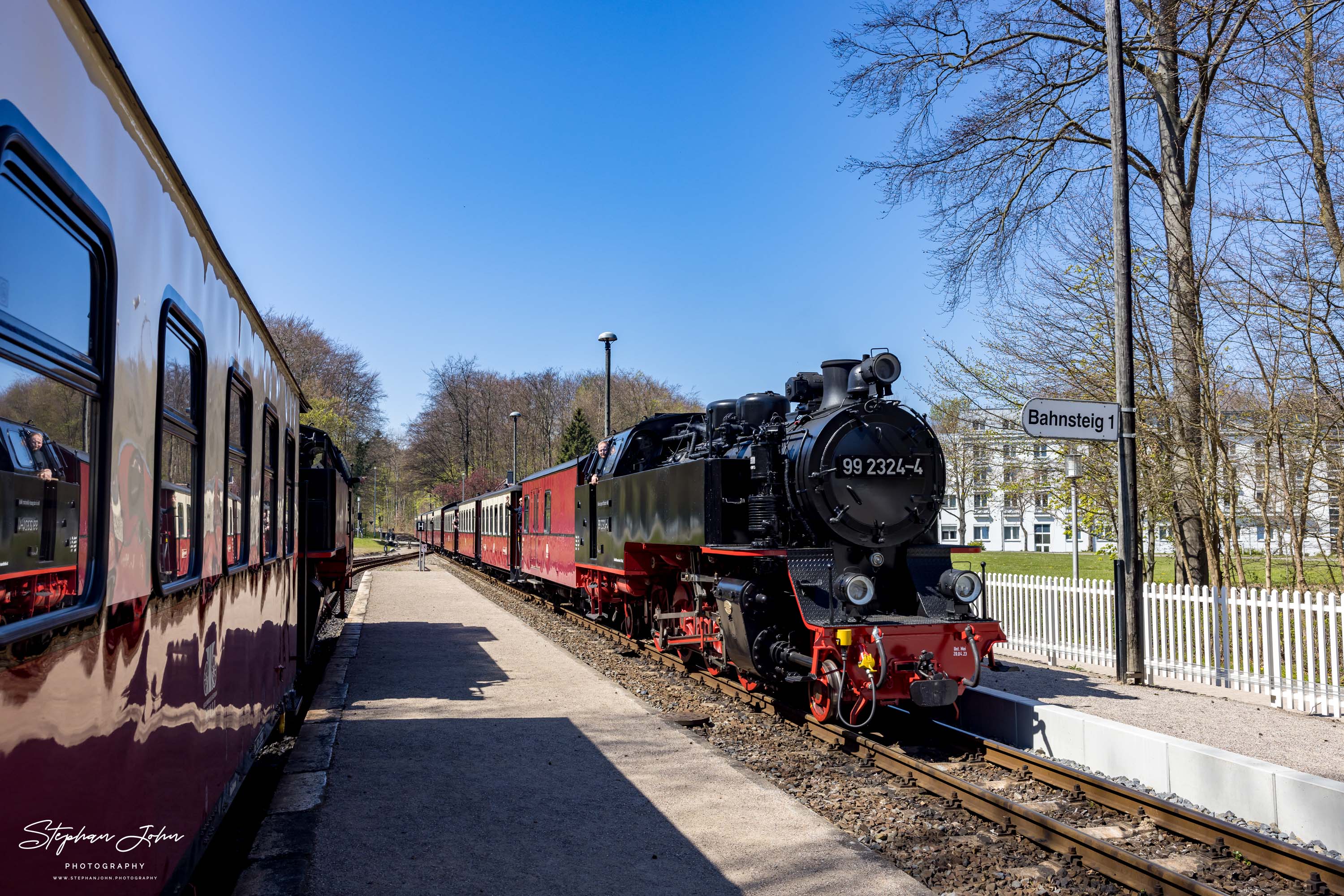 Lok 99 2324-4 mit einem Personenzug von Kühlungsborn nach Bad Doberan fährt in den Bahnhof Heiligendamm ein.