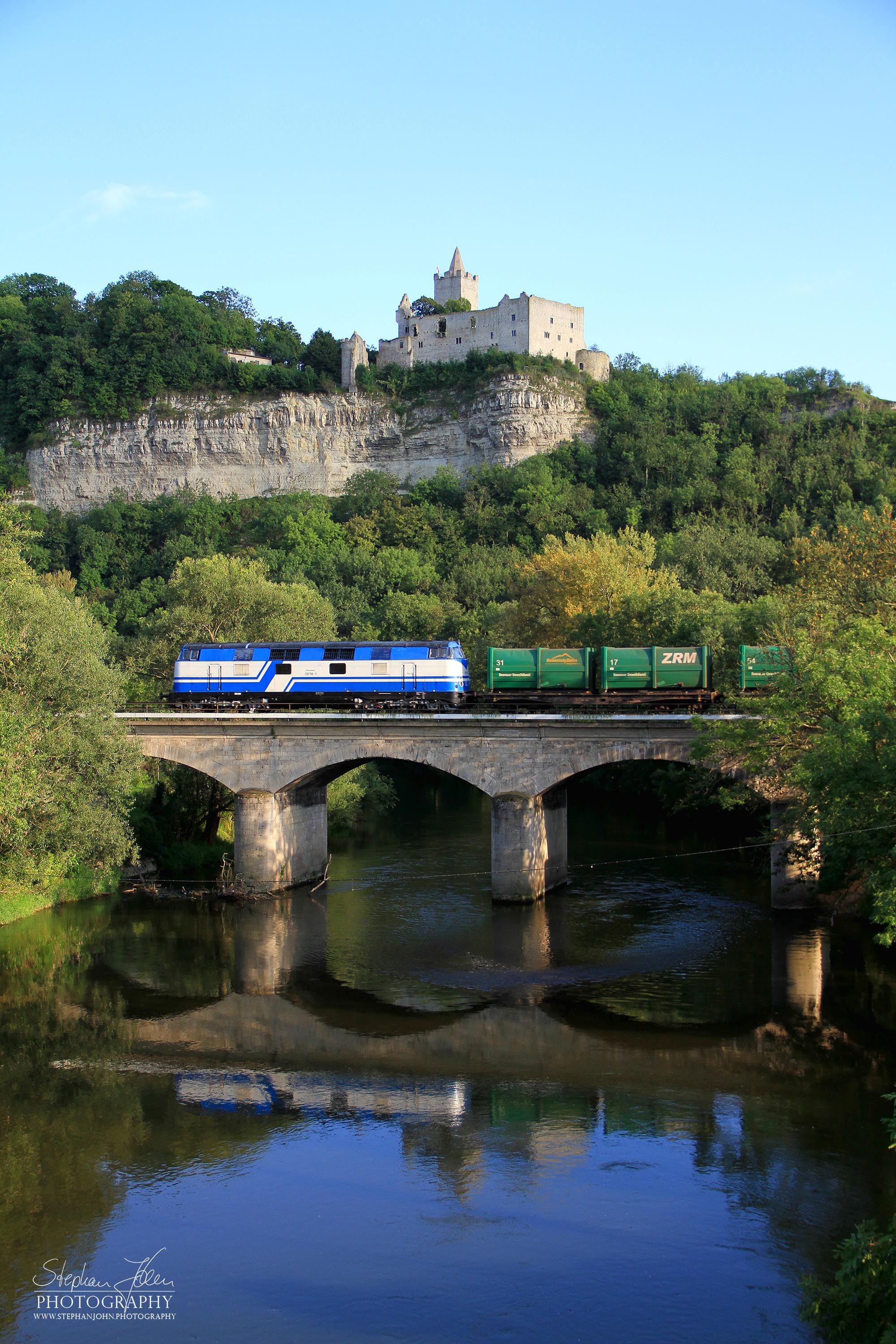 Ein Güterzug mit Müllwagen aus Ilmenau nach Großkorbetha überqurt mit Lok 228 758-9 der Rennsteigbahn die Saalebrücke bei Saaleck. Im Hintergrund ist die Rudelsburg zu sehen.