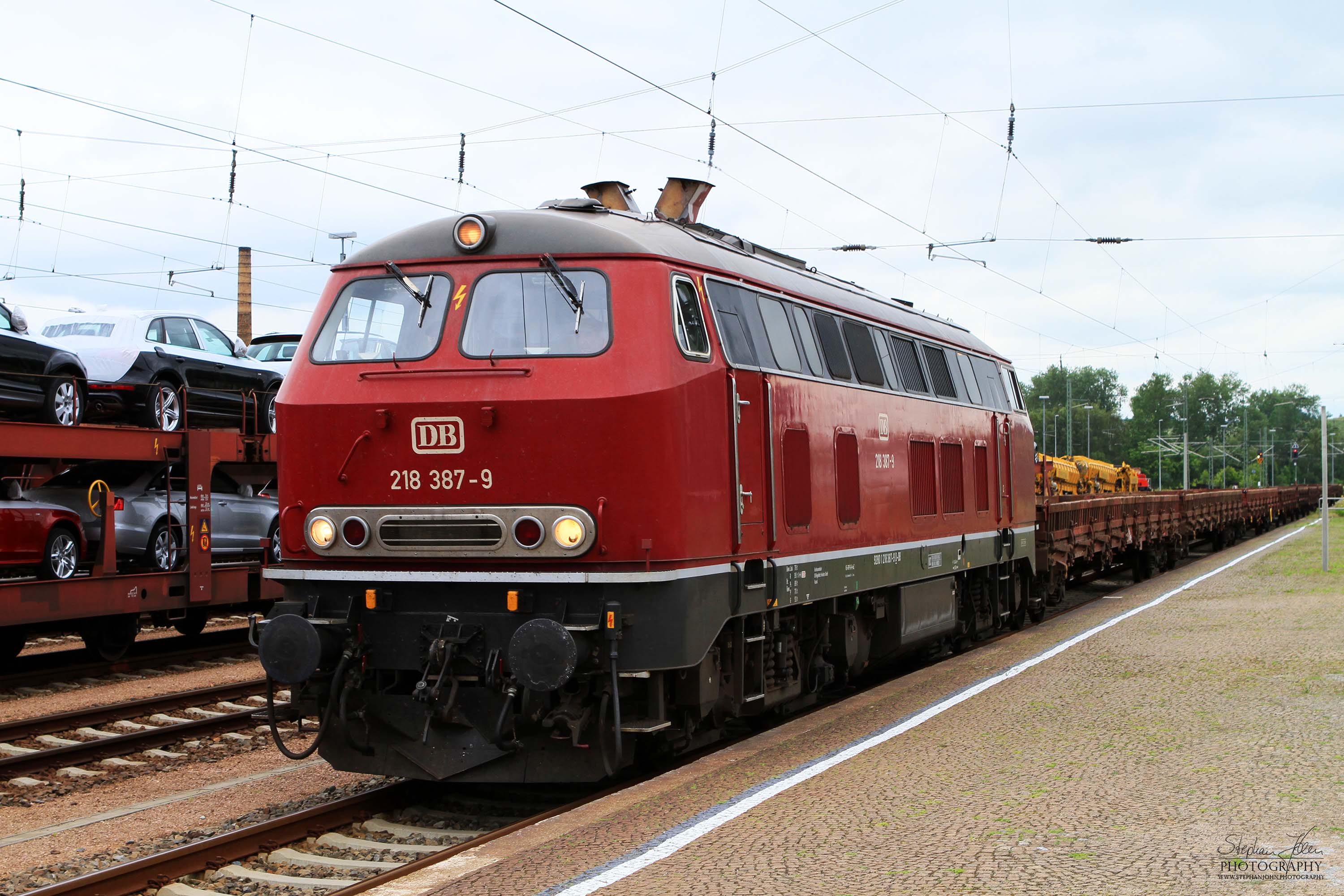 Lok BR 218 387-9 fährt mit einem Güterzug durch den Bahnhof Glauchau (Sachs)