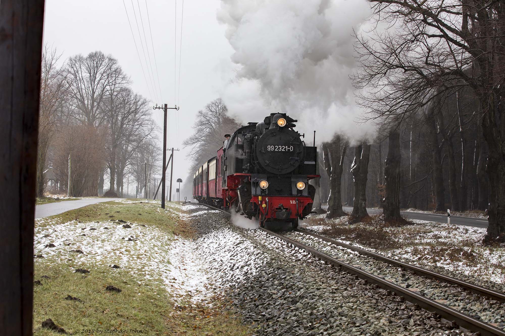 Lok 99 2321-0 mit einem Personenzug der Epoche IV während der Durchfahrt durch den Bahnhof Rennbahn. Die Zugbildung entspricht der Zeit zwischen 1980 und 1983, als die Personenwagen modernisiert wurden.