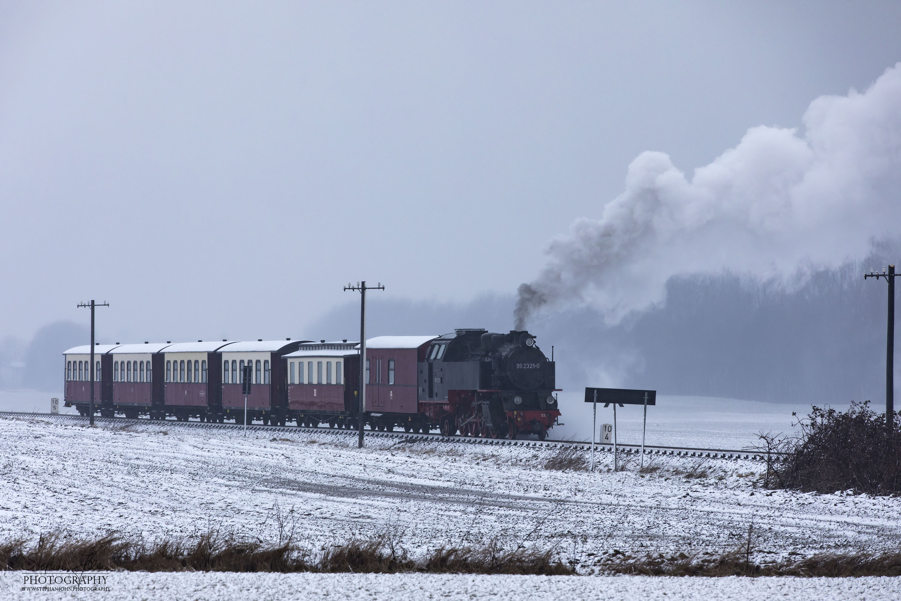 Lok 99 2321-0 mit einem Personenzug der Epoche IV kurz vor dem Haltepunkt Steilküste. Die Zugbildung entspricht der Zeit zwischen 1980 und 1983, als die Personenwagen modernisiert wurden.