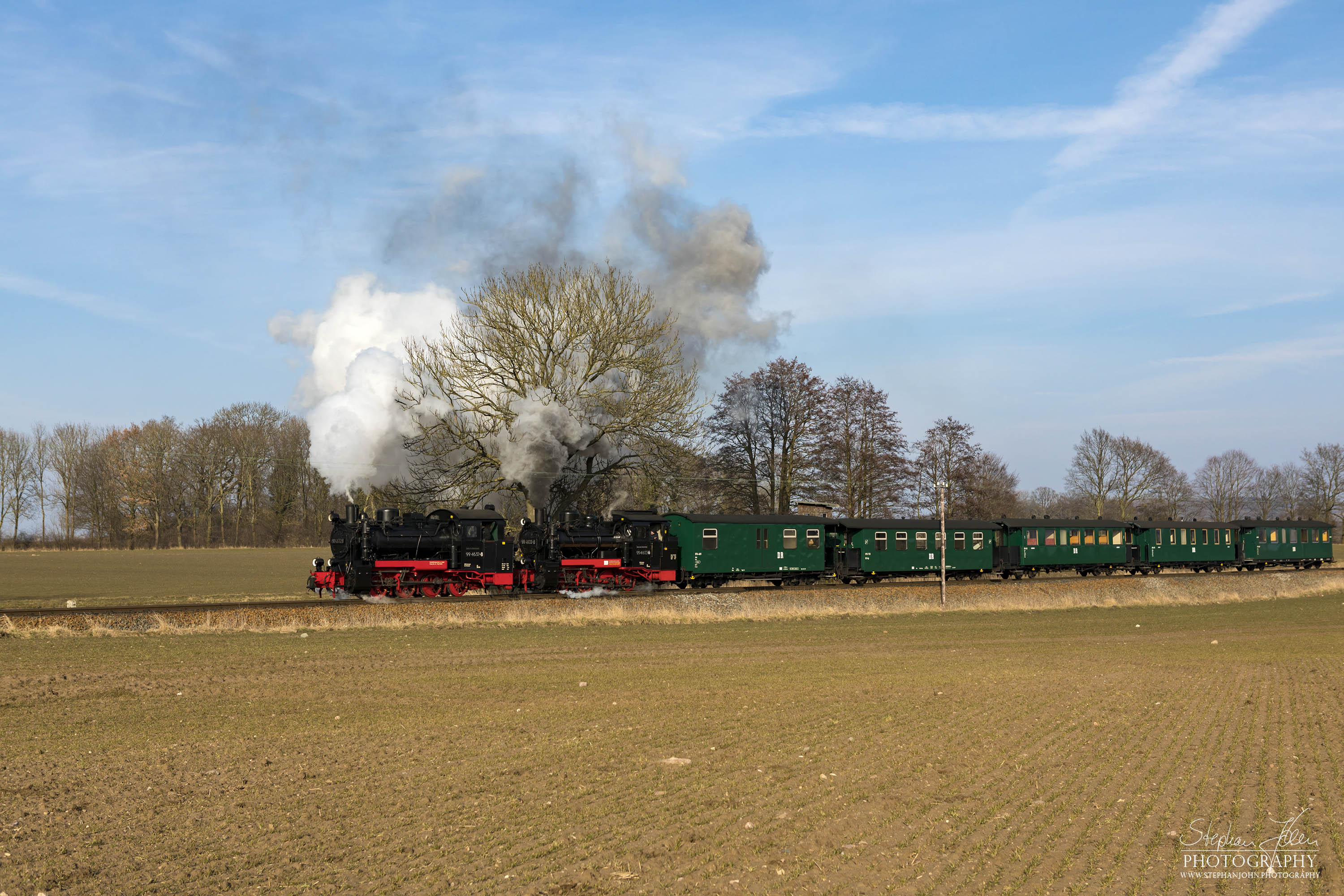 Seit der Hauptuntersuchung im Januar 2018 hat die Rügen-Lok 99 4632-8 (Vulcan-Lok) wieder eine schwarze Reichsbahnlackierung. Die Rügen-Lok 99 4633-6 hat noch in diesem Jahr Fristablauf und kommt dann in grüner Farbgebung wieder. Beide Rügenloks in schwarzer Farbgebung ist also nur ein kurzes Vergnügen. Hier zieht die Lok 99 4633-6 mit Vorspannlok 99 4632-8 nach Posewald einen Personenzug in Richtung Putbus. 