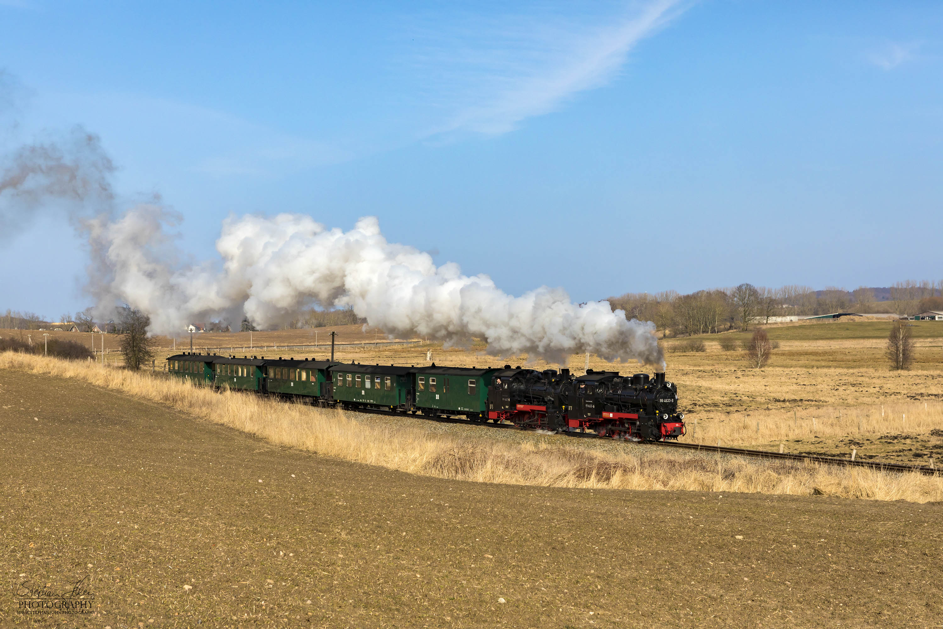 Seit der Hauptuntersuchung im Januar 2018 hat die Rügen-Lok 99 4632-8 (Vulcan-Lok) wieder eine schwarze Reichsbahnlackierung. Die Rügen-Lok 99 4633-6 hat noch in diesem Jahr Fristablauf und kommt dann in grüner Farbgebung wieder. Beide Rügenloks in schwarzer Farbgebung ist also nur ein kurzes Vergnügen. Hier zieht die Lok 99 4632-8 mit Vorspannlok 99 4633-6 zwischen Serams und Seelvitz einen Personenzug in Richtung Putbus. 