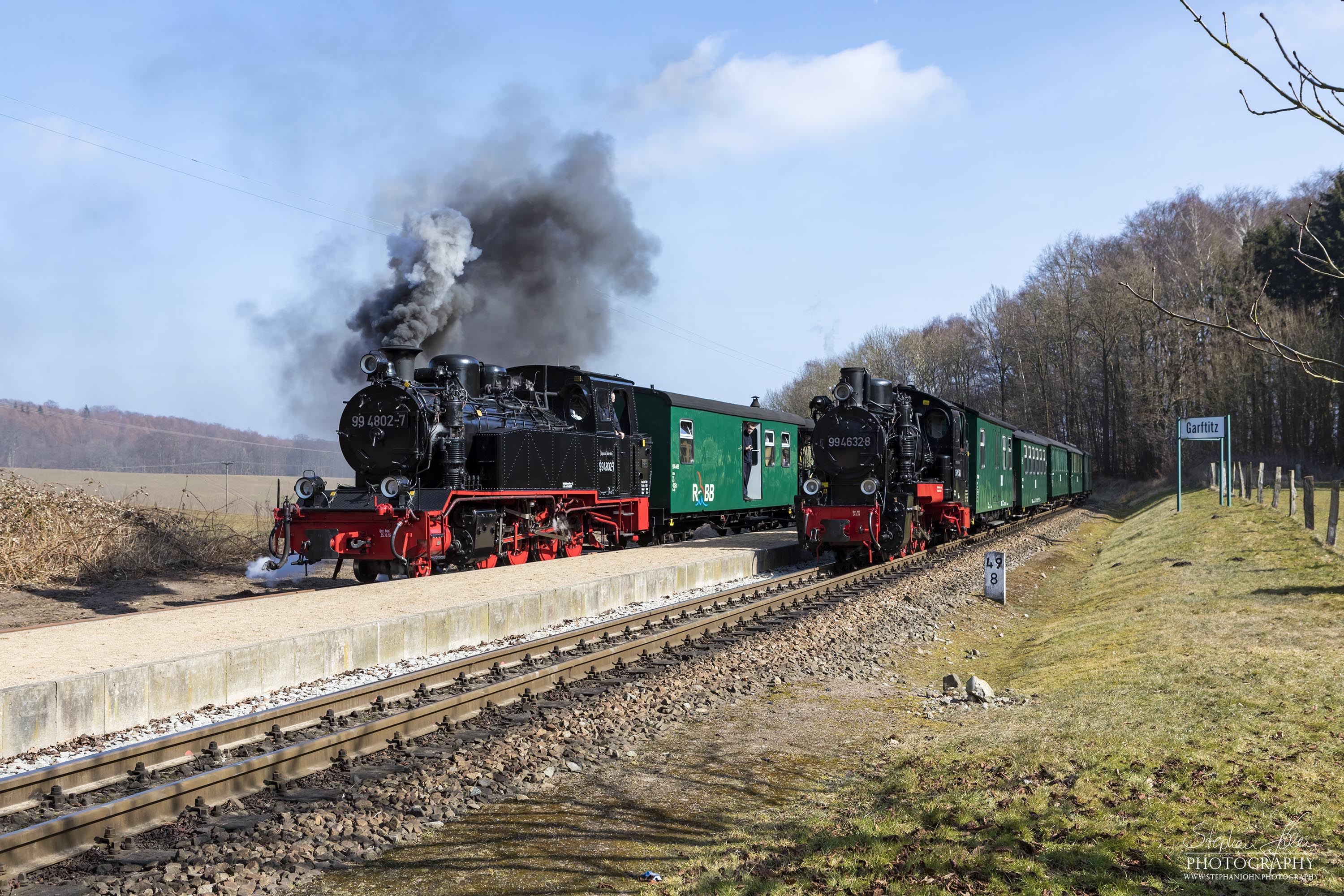 Seit der Hauptuntersuchung im Januar 2018 hat die Rügen-Lok 99 4632-8 (Vulcan-Lok) wieder eine schwarze Reichsbahnlackierung. Hier wartet die Lok in Garftitz mit einem Personenzug auf die Überholung durch einen Planzug nach Putbus.