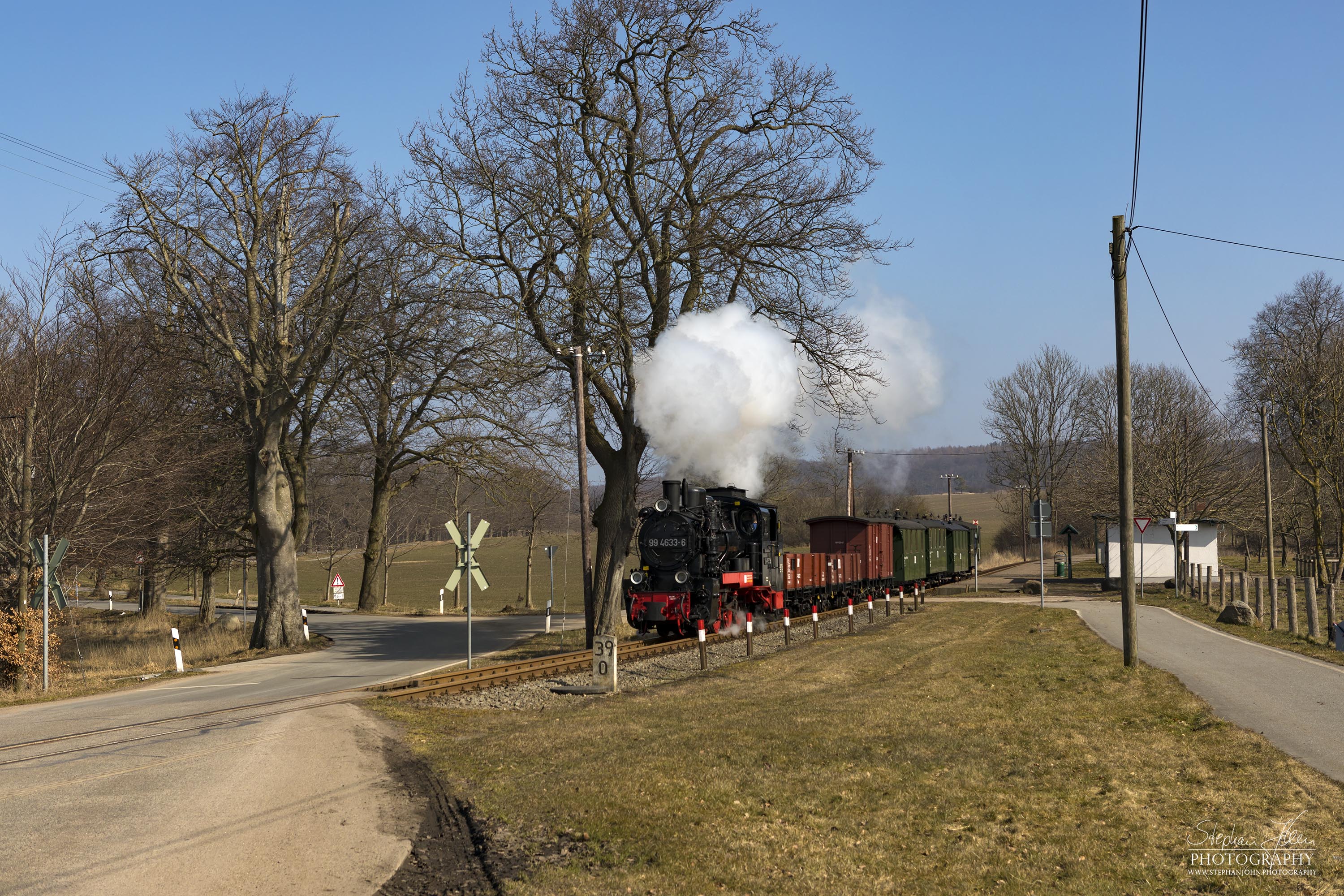 Die Rügen-Lok 99 4633-6 dampft mit einem GmP in Richtung Putbus. Hier fährt der Zug gerade am Haltepunkt Posewald durch.