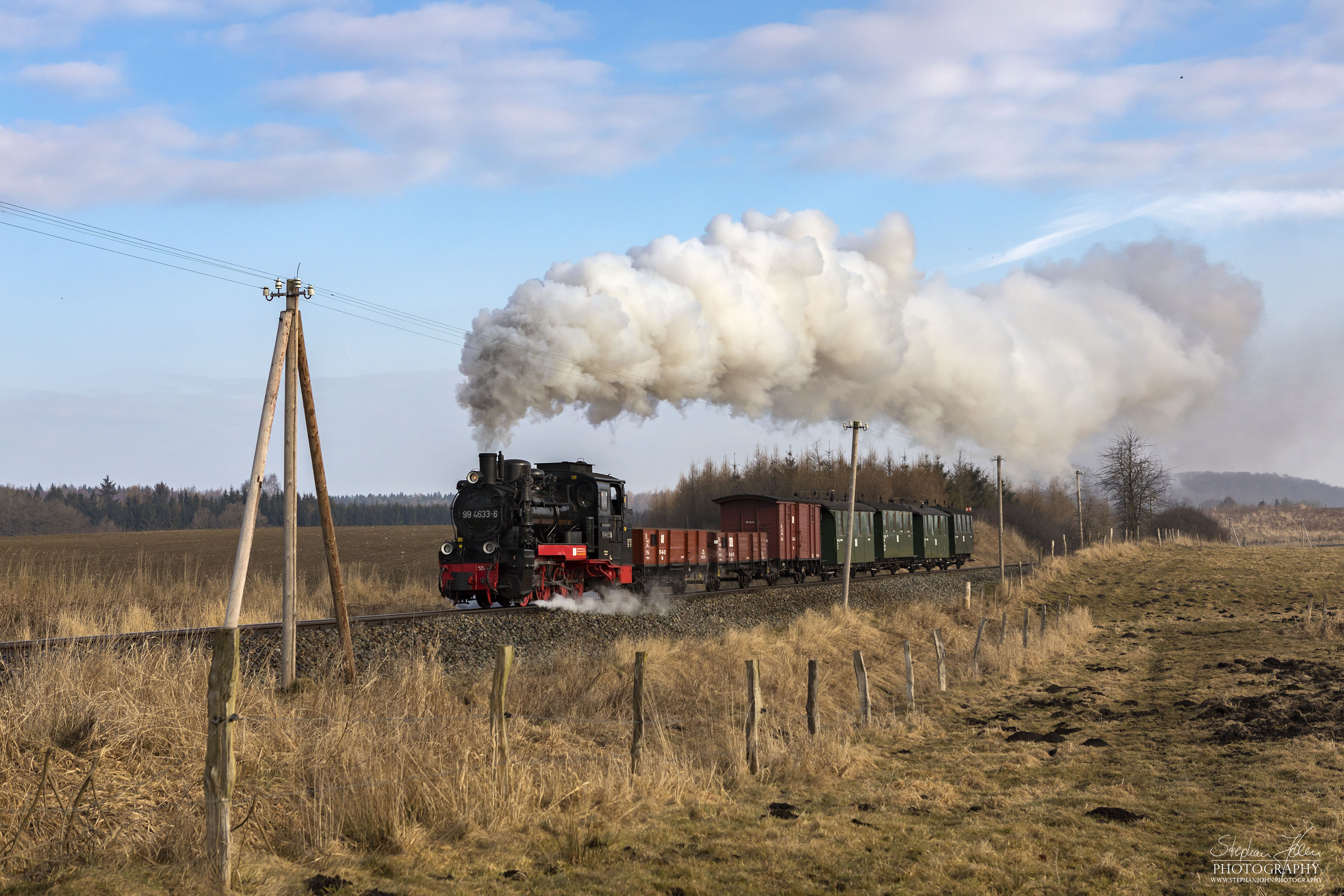 Die Rügen-Lok 99 4633-6 dampft mit einem morgentlichen GmP in Richtung Putbus. Hier werden gerade die Wiesen zwischen Serams und Seelvitz passiert