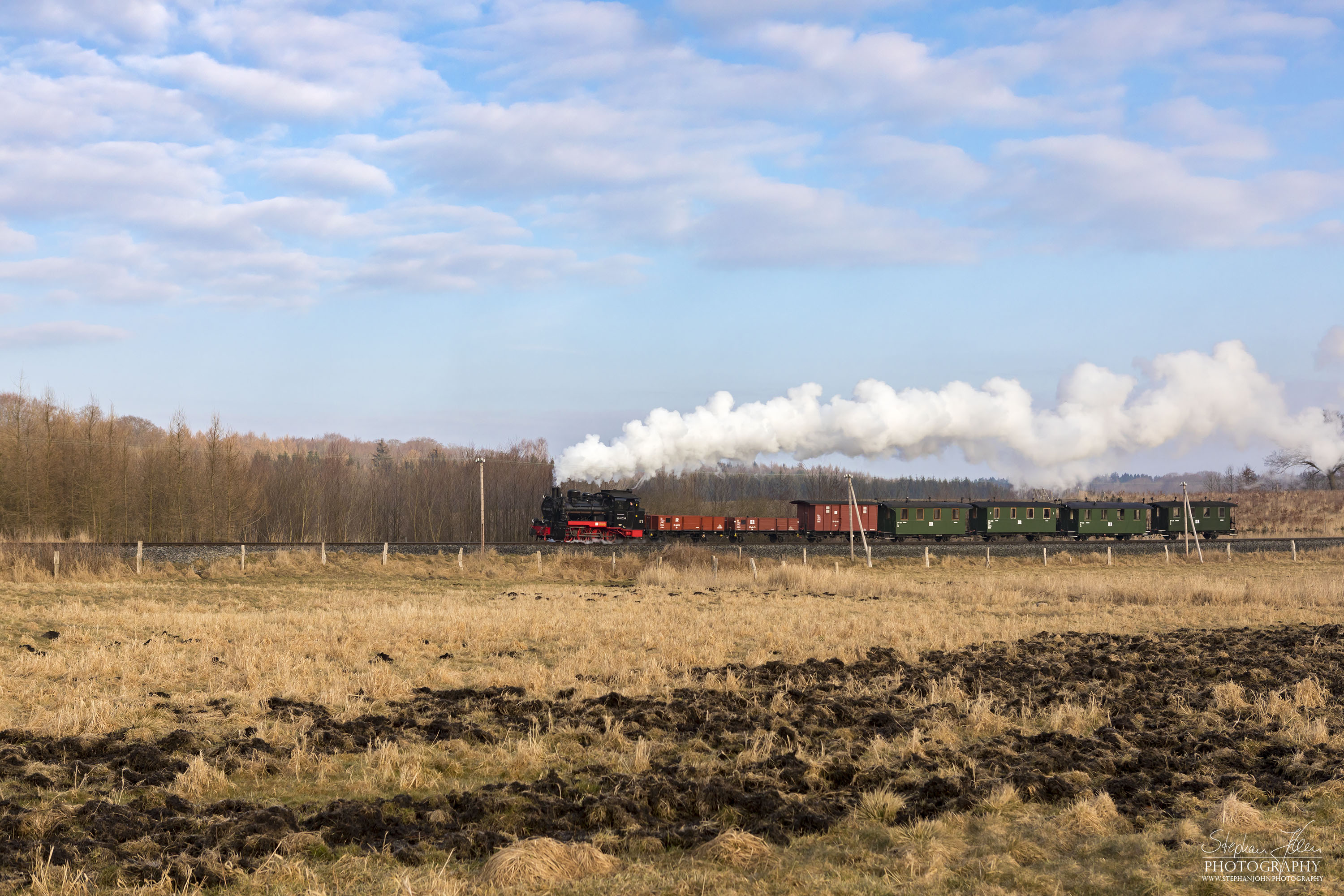 Die Rügen-Lok 99 4633-6 dampft mit einem morgentlichen GmP in Richtung Putbus. Hier werden gerade die Wiesen zwischen Serams und Seelvitz passiert