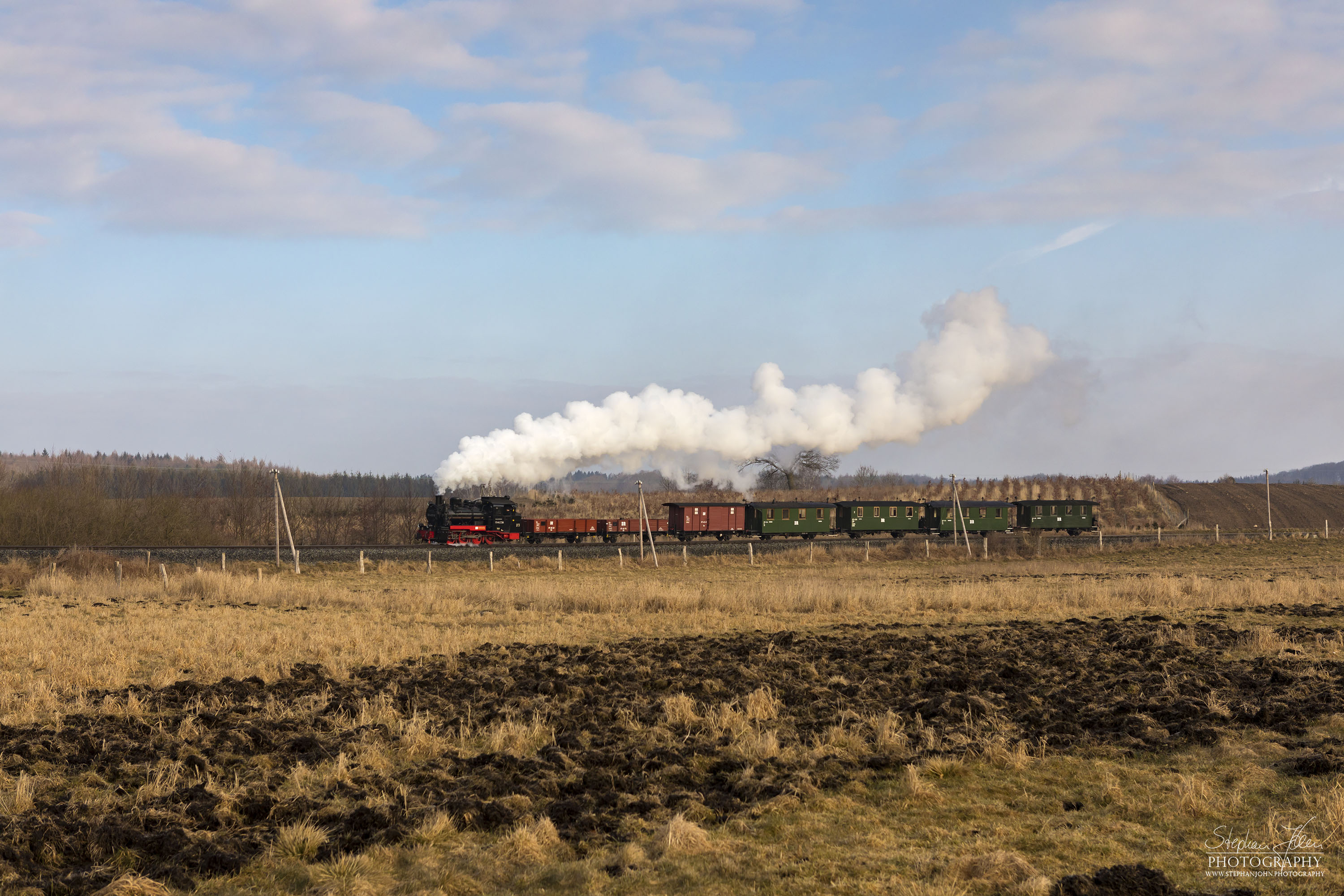 Die Rügen-Lok 99 4633-6 dampft mit einem morgentlichen GmP in Richtung Putbus. Hier werden gerade die von Wildschweinen durchwühlten Wiesen zwischen Serams und Seelvitz passiert