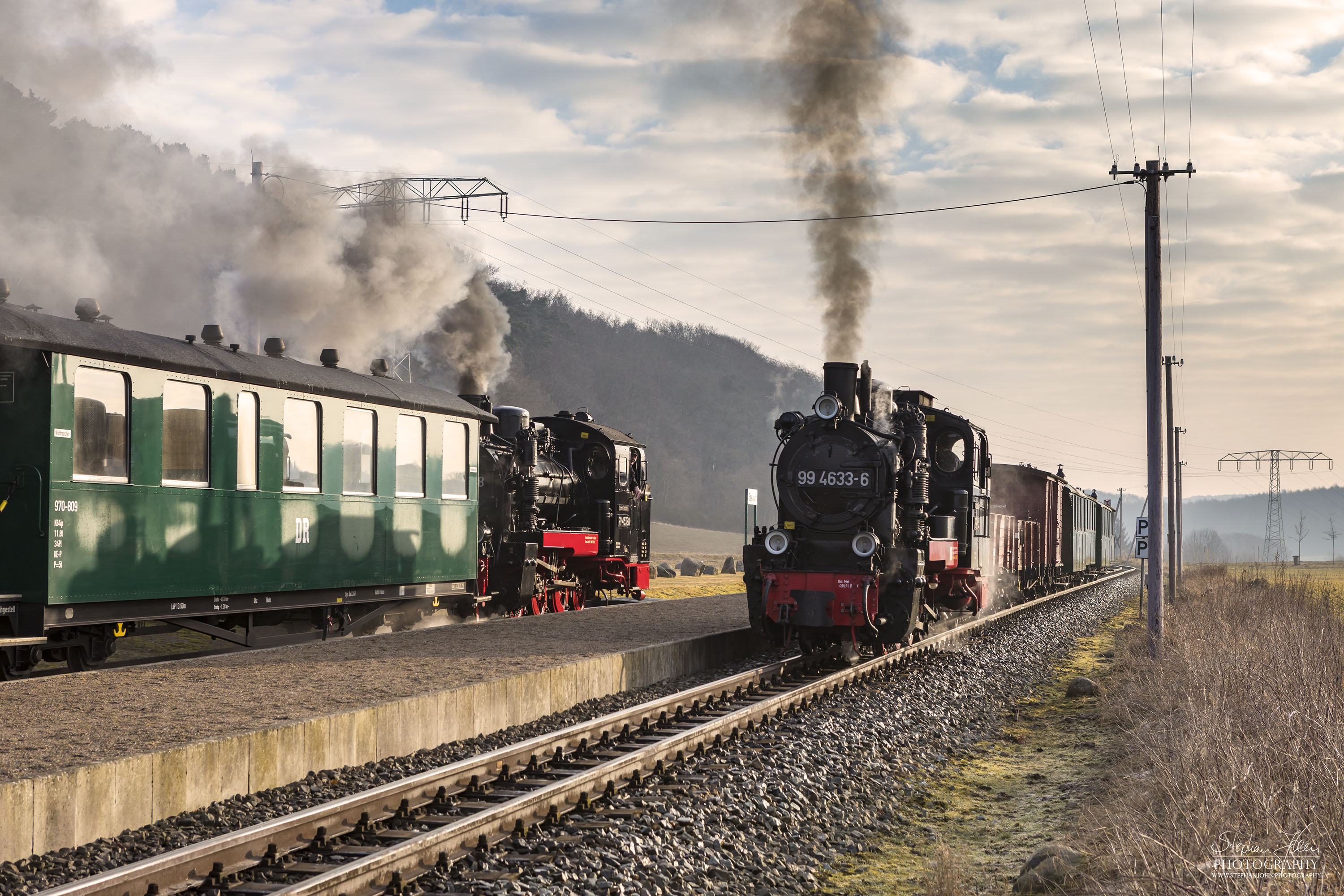 Kreuzung im Bahnhof Seelvitz zwischen einem GmP nach Putbus mit Lok 99 4633-6 und dem ersten Personenzug des Tages nach Göhren mit Lok 99 4632-8. Beide Rügen-Loks sind für wenige Monate in schwarzer Reichsbahnfarbgebung unterwegs, bis Lok 99 4633-6 nach der Hauptuntersuchung wieder in grüner Farbgebung unterwegs sein wird.