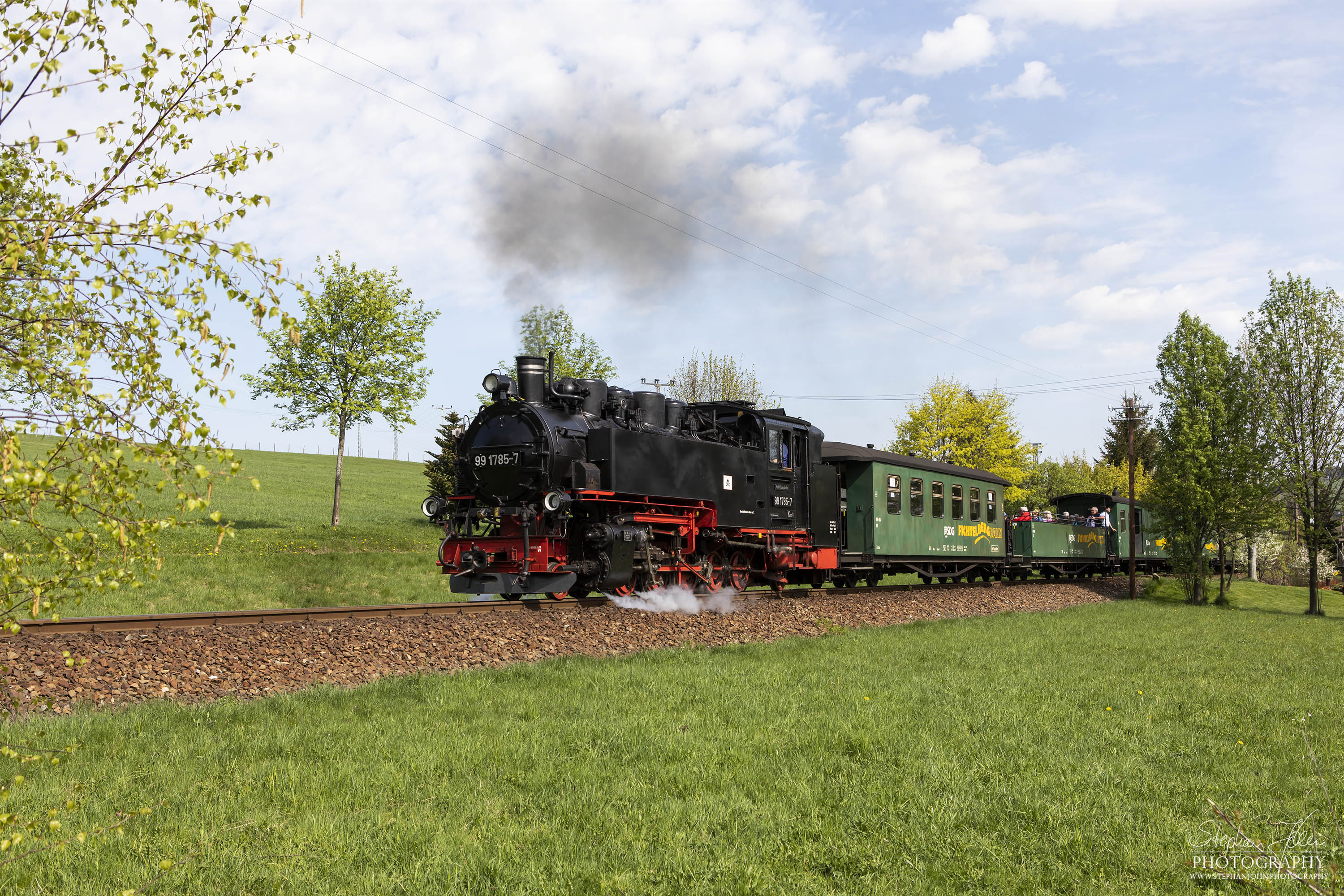 Zug P 1001 mit Lok 99 1785-7 auf dem Weg von Cranzahl nach Oberwiesenthal. Hier dampft der Zug bei bestem Fotowetter hinter der Ortslage Neudorf dem Bahnhof Vierenstraße zu