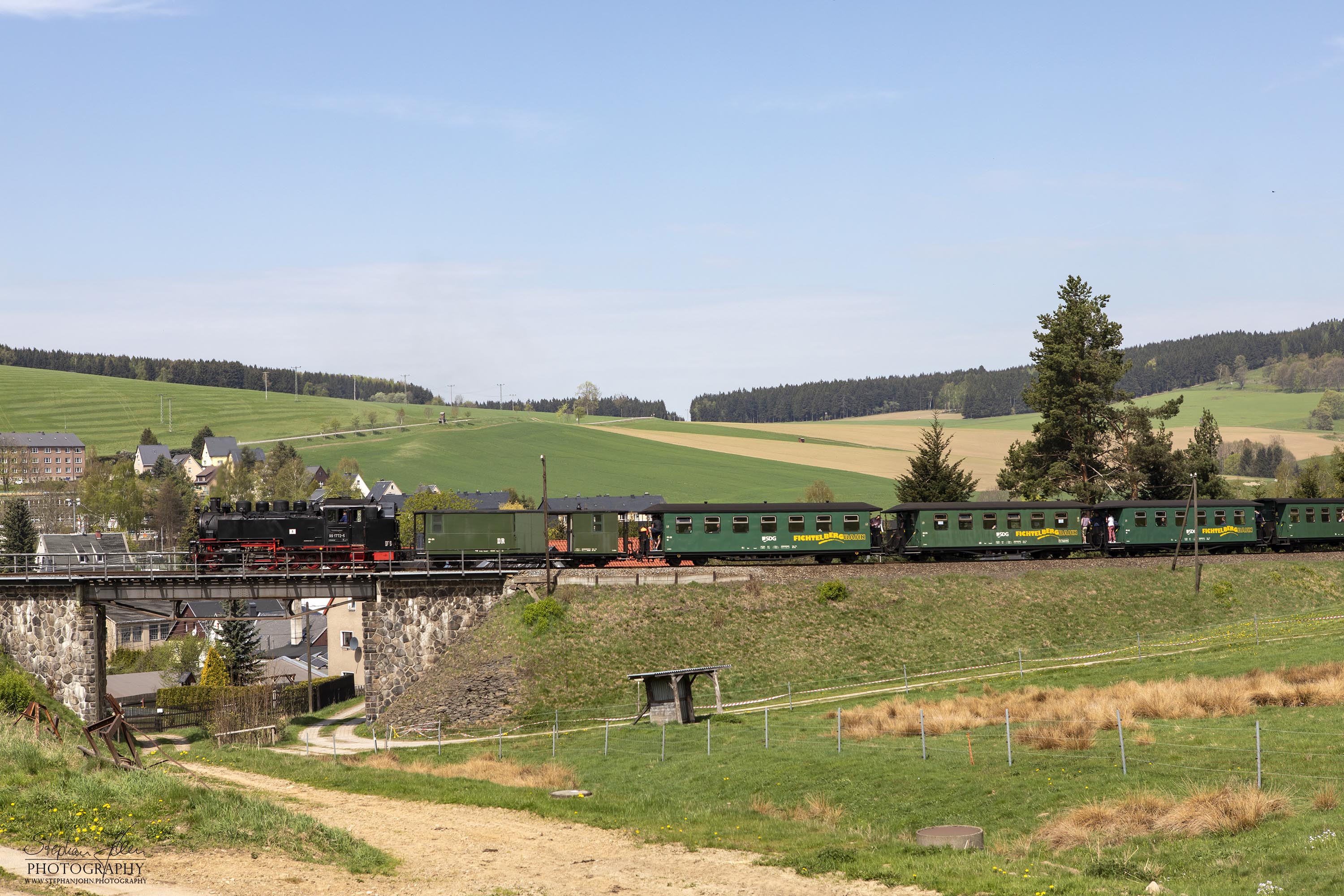 Zug P 1003 mit Lok 99 1772-5 auf dem Weg von Cranzahl nach Oberwiesenthal. Hier passiert der Zug eine kleine Brücke zwischen Unterneudorf und Neudorf.