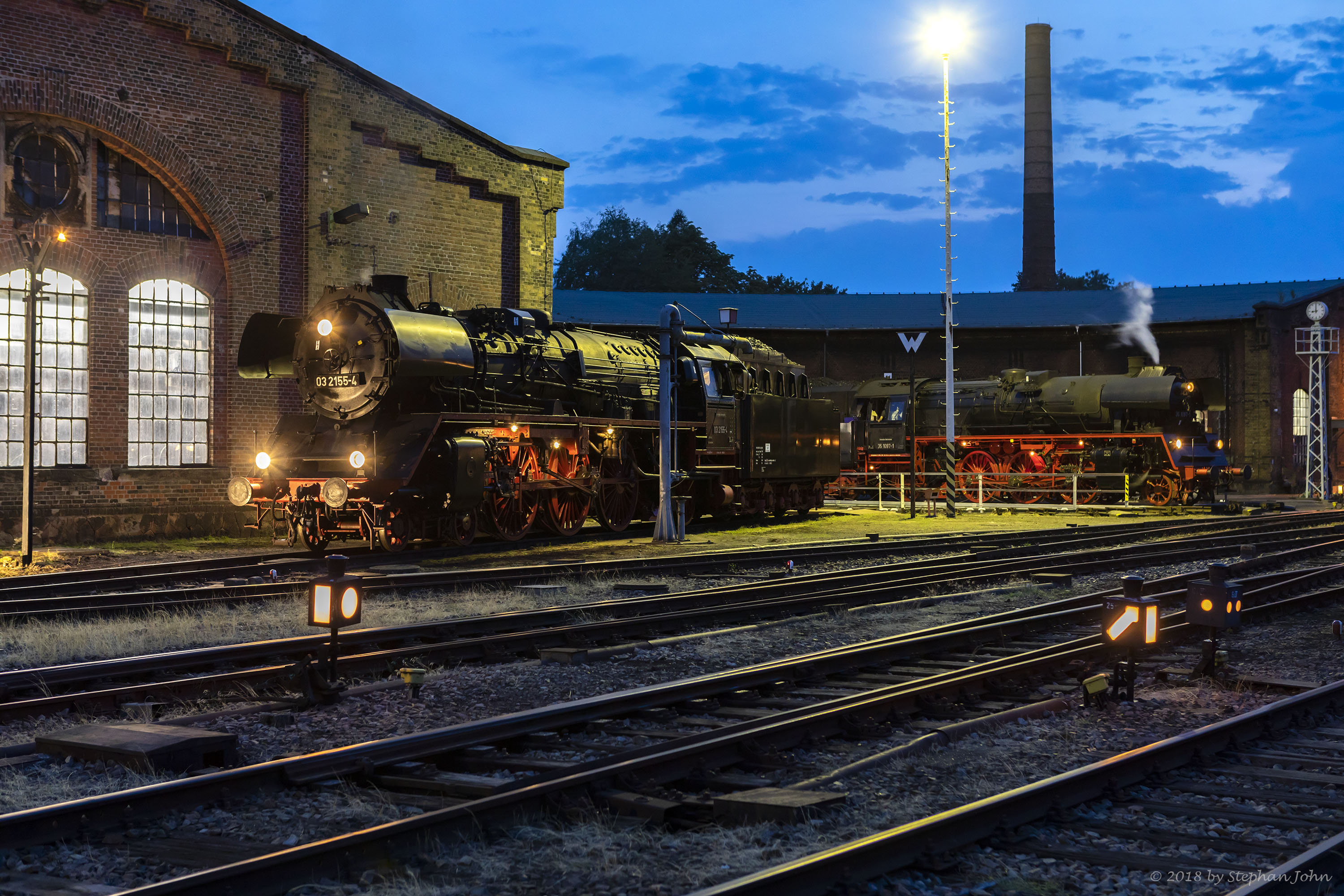 Während Lok 03 2155-4 am Schuppen steht, wird Lok 35 1097-1 auf der Drehscheibe in den Lokschuppen gefahren.