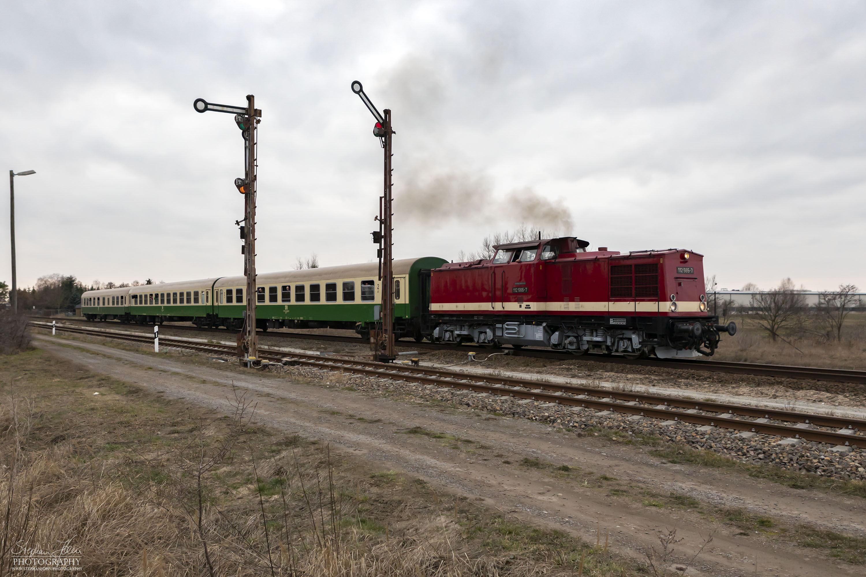 Zug 74325 mit Lok 112 565-7 nach Dessau Hbf  färt nach einer Kreuzung aus dem Bahnhof Elsnigk