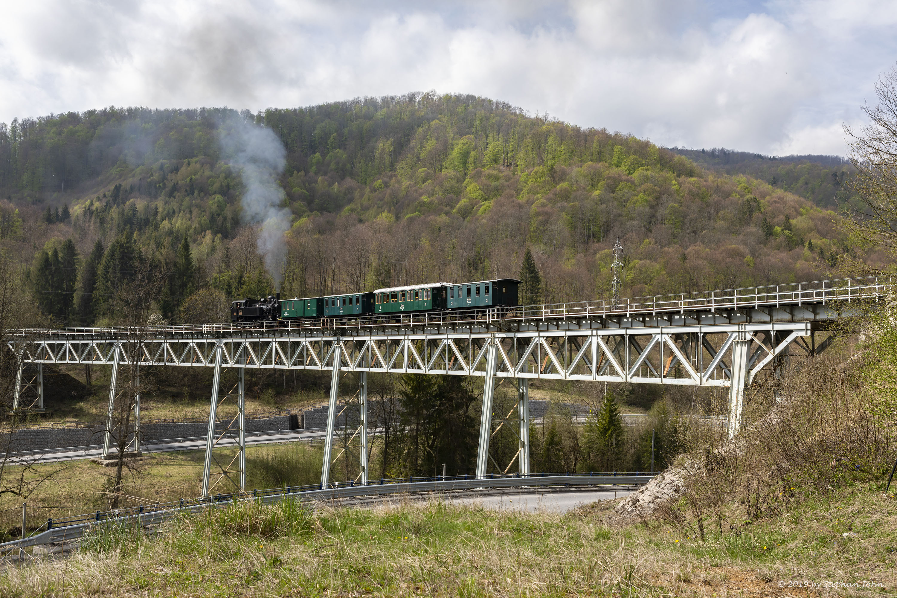 <p>Die Lok 4296 schiebt den Zug über die Steigung nach Zbojská. Hier befindet sich der Zug auf dem Viadukt 