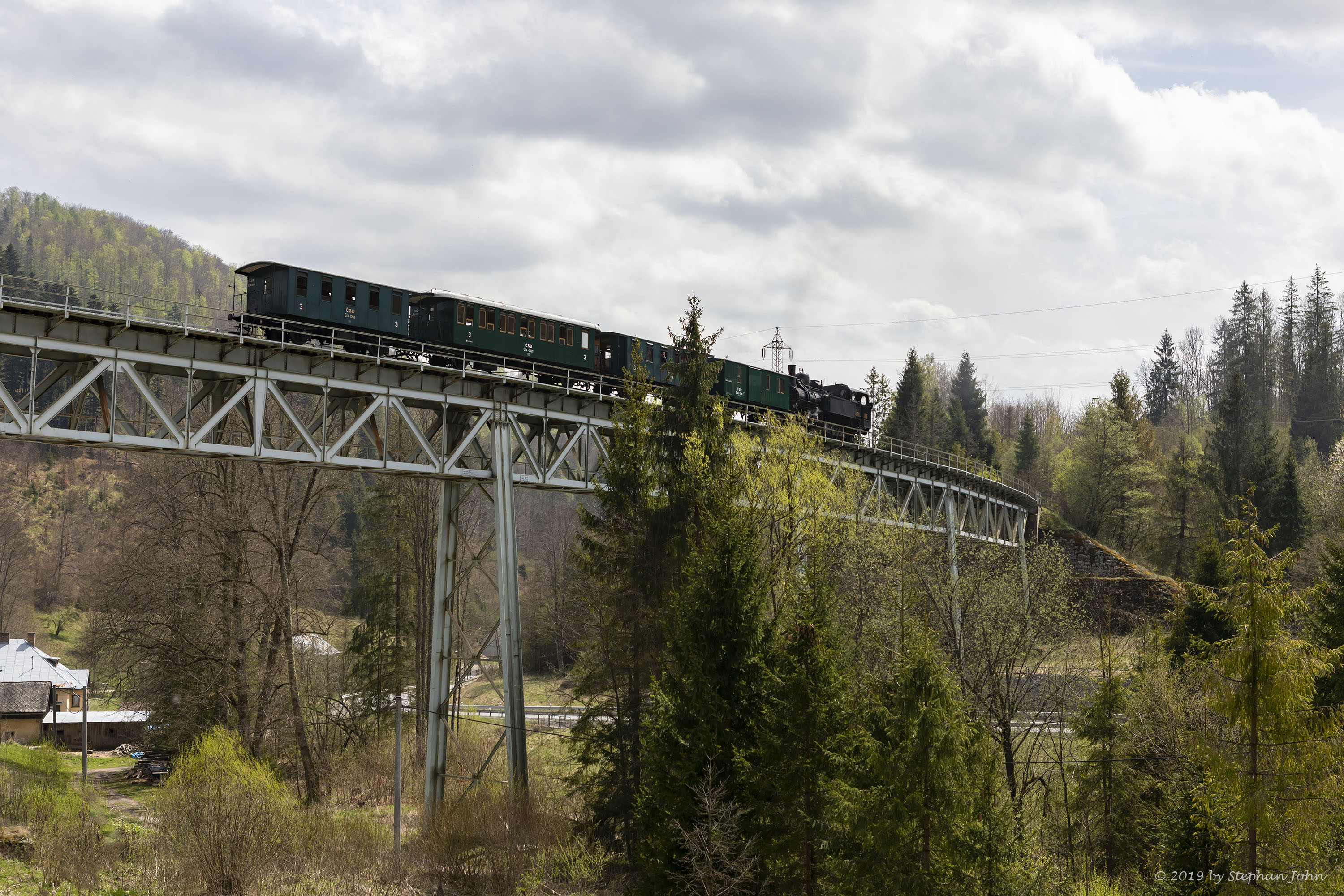 <p>Die Lok 4296 schiebt den Zug über die Steigung nach Zbojská. Hier befindet sich der Zug auf dem Viadukt 