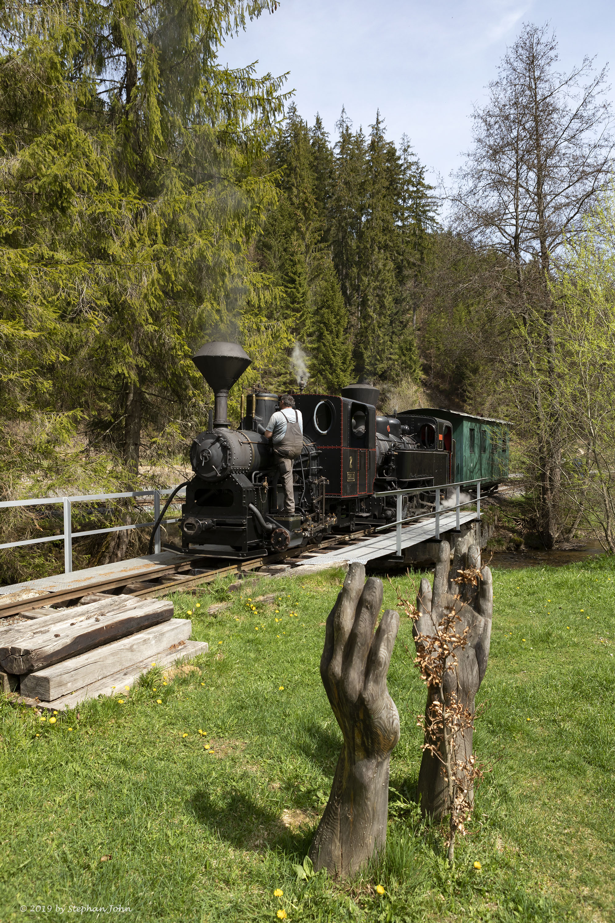 <p>Die beiden Lokomotiven des Holzzuges nehmen Wasser aus dem Fluss</p>