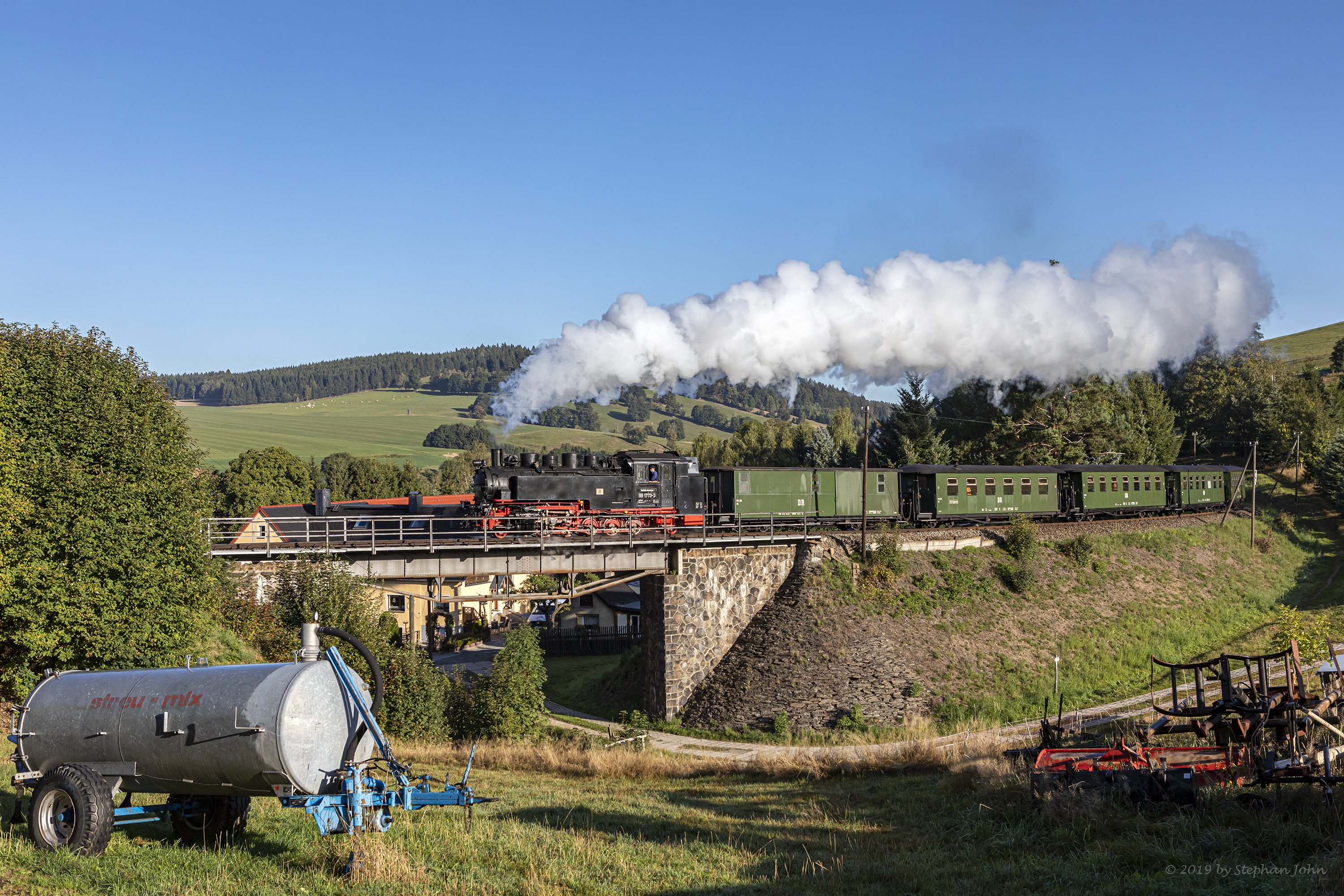 Zug 9005 mit Lok 99 1773-3 fährt mit dem Personenzug in Richtung Oberwiesenthal und passiert hier eine Brücke in Neudorf.
