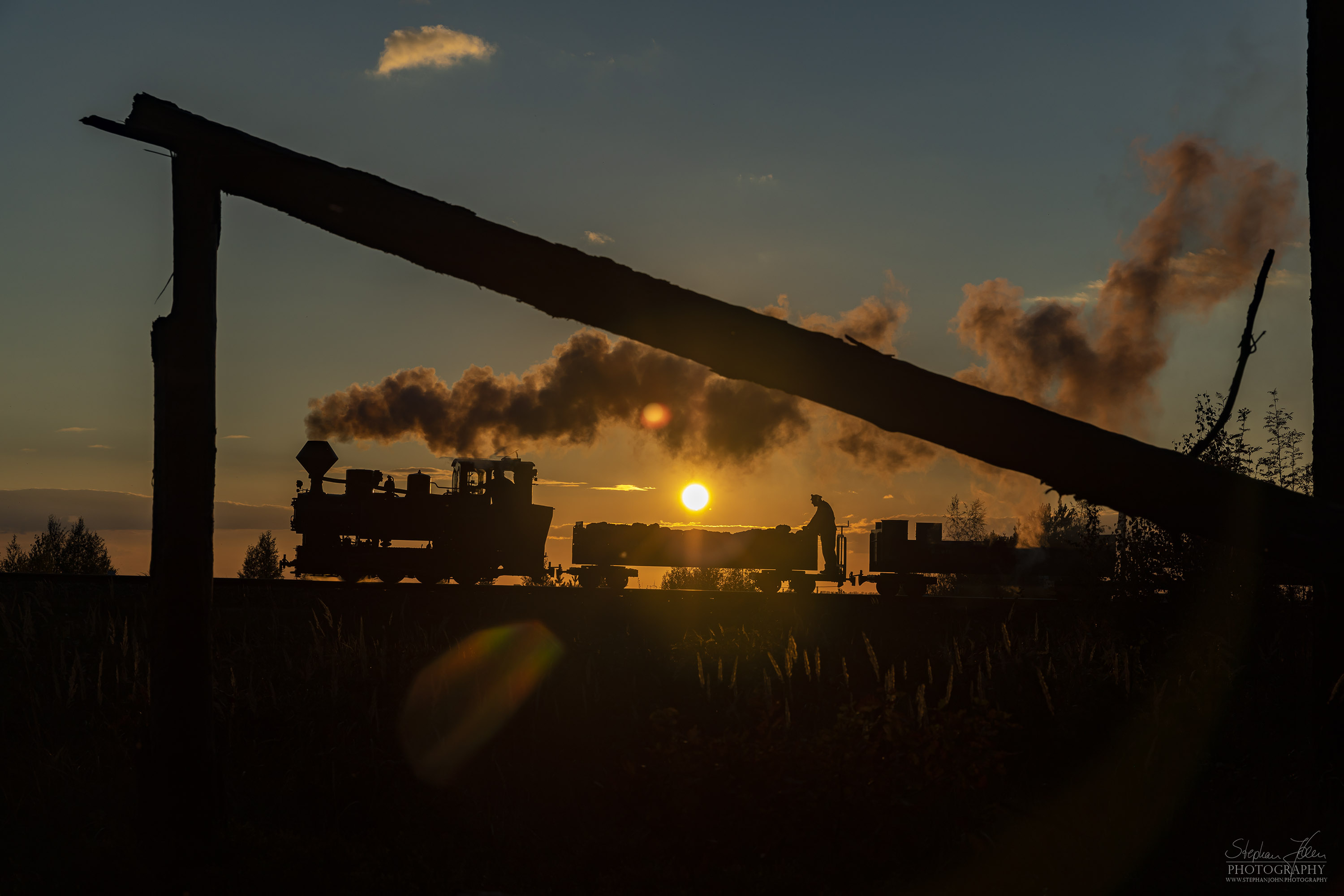 Lok 99 3312 zieht einen Güterzug im Sonnenuntergang zum Schweren Berg