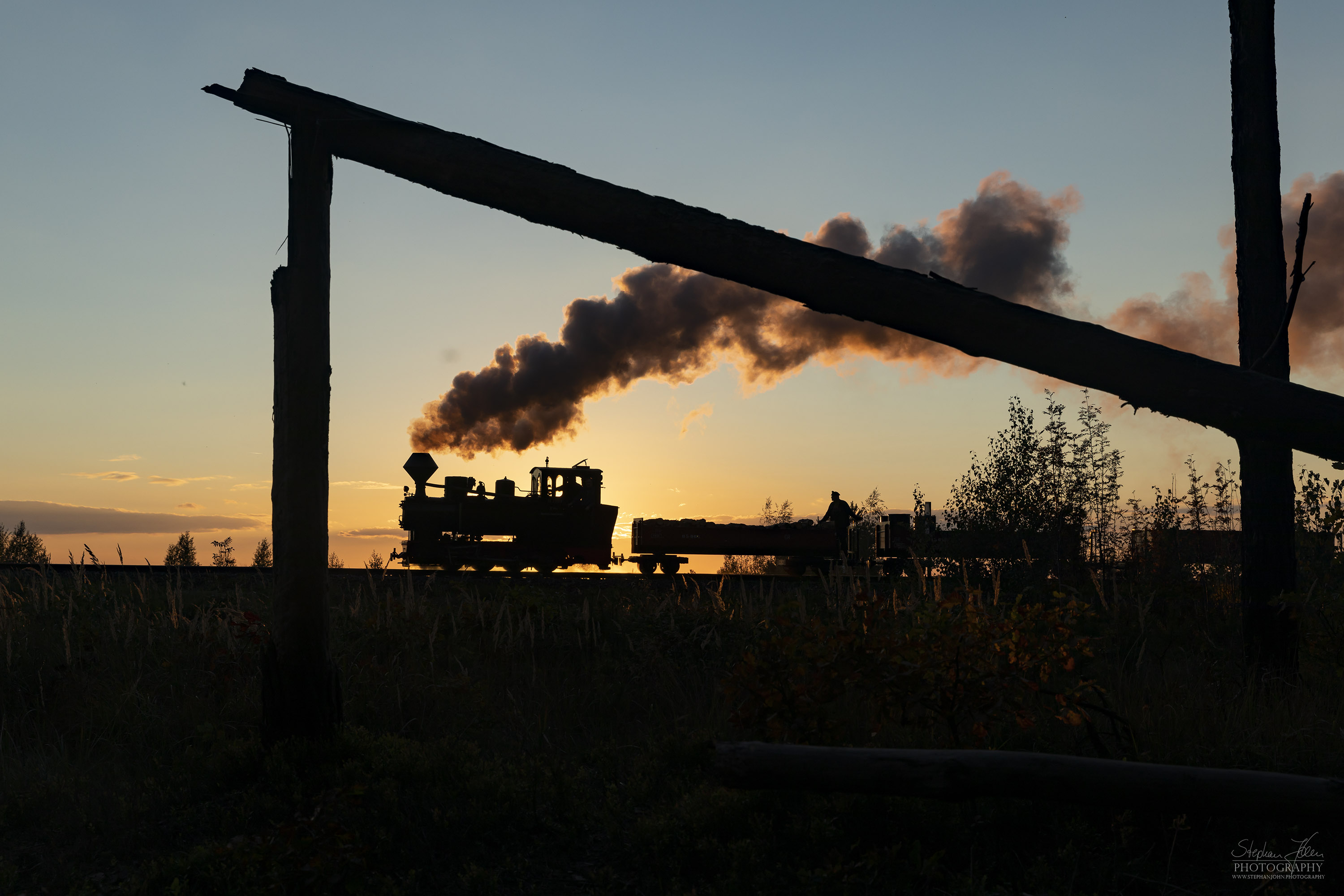 Lok 99 3312 zieht einen Güterzug im Sonnenuntergang zum Schweren Berg