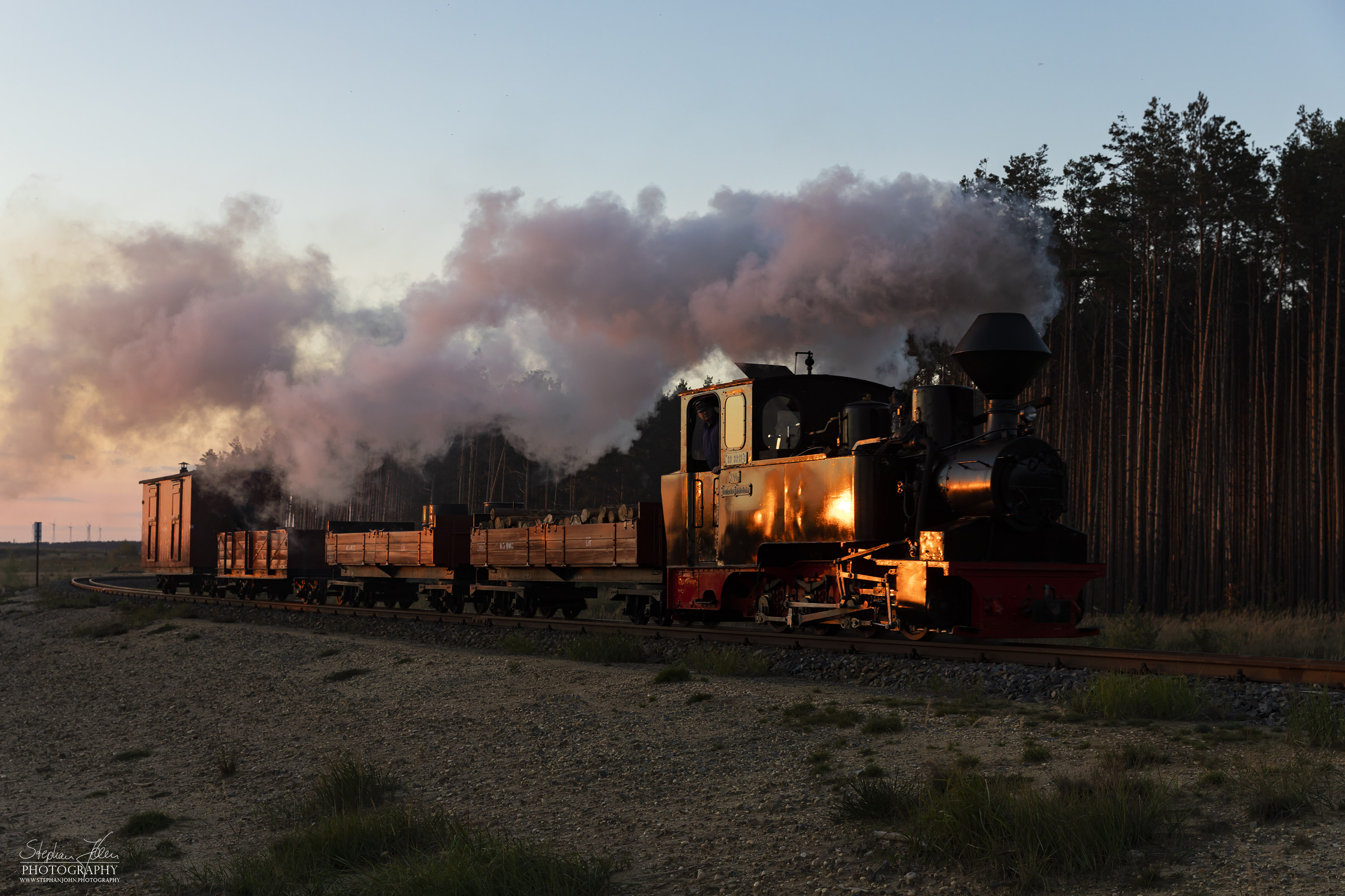 Lok 99 3312 zieht einen Güterzug im Sonnenuntergang zum Schweren Berg