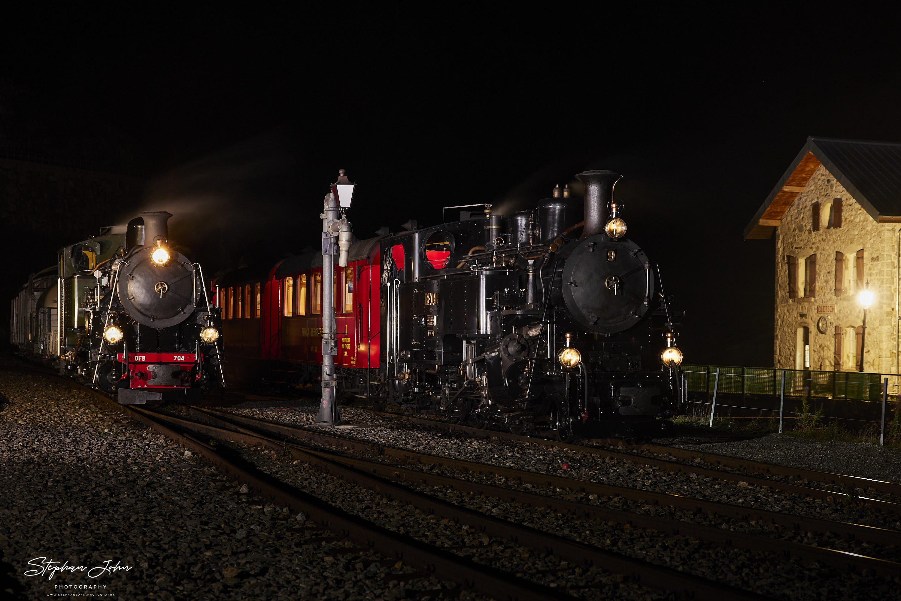 <p>Bahnhof Gletsch am Abend. Lok 9 mit einem Personenzug und Lok 704 mit einem Güterzug stehen abfahrtbereit in Richtung Furka.</p>