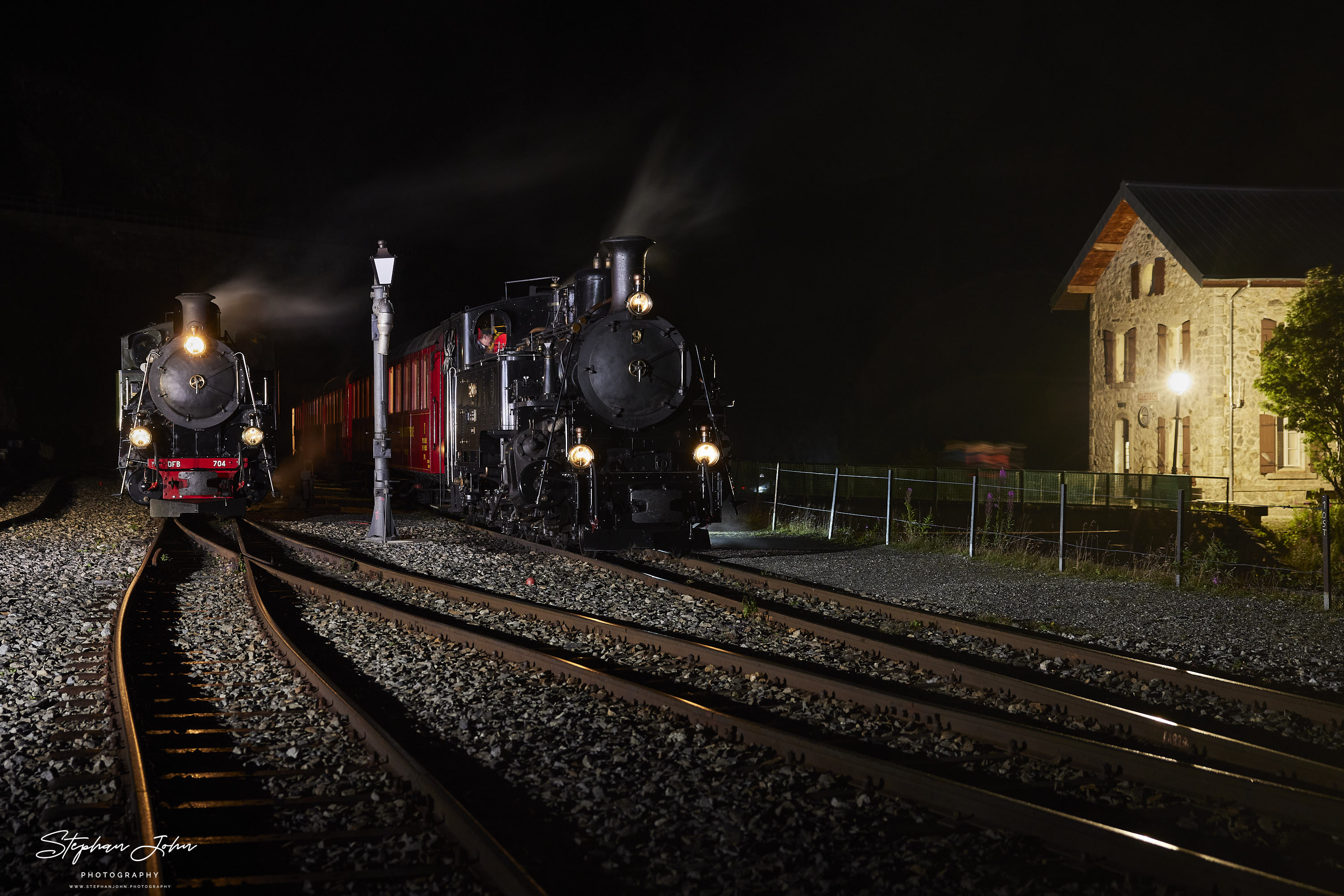 Bahnhog Gletsch am Abend. Lok 9 mit einem Personenzug und Lok 704 mit einem Güterzug stehen abfahrtbereit in Richtung Furka.