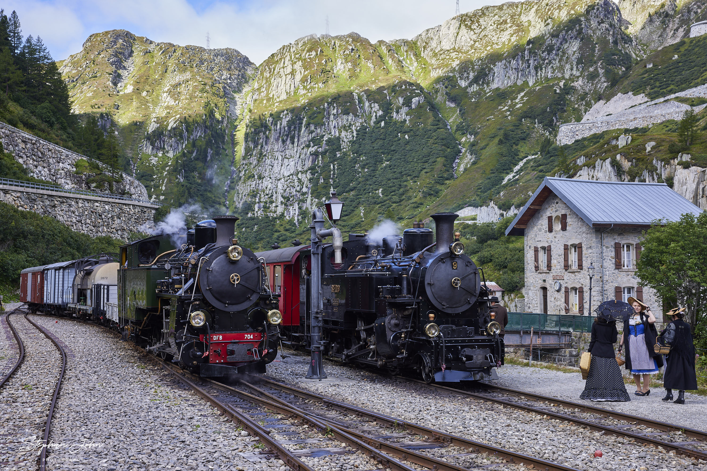 Lok 9 der DFB mit einem Personenzug und Lok 704 der DFB mit einem Güterzug warten abfahrtbereit im Bahnhof Gletsch.