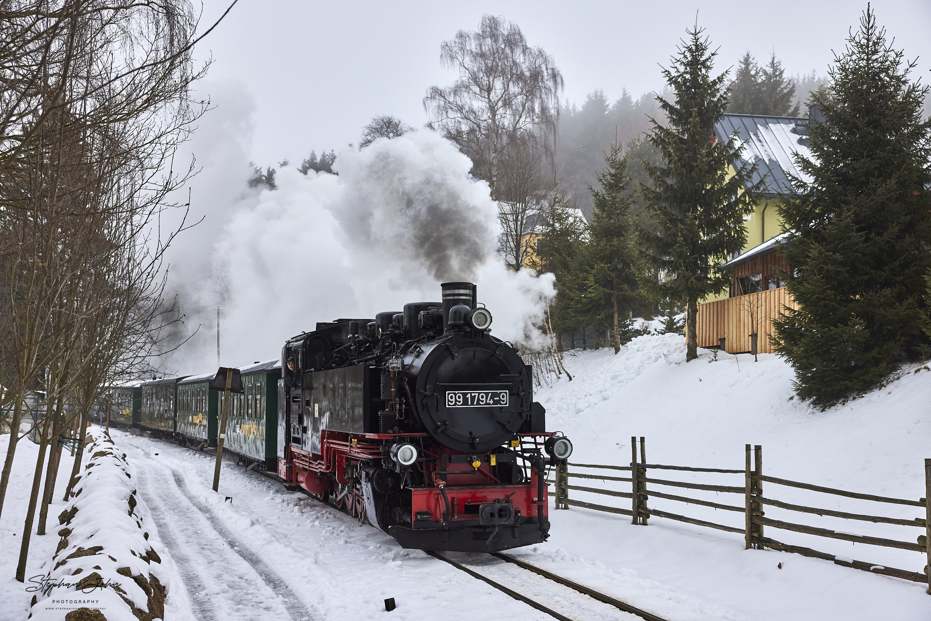 Zug P 1001 mit Lok 99 1794-9 dampft durch Neudorf und erreicht gleich den Bahnhof des Ortes.