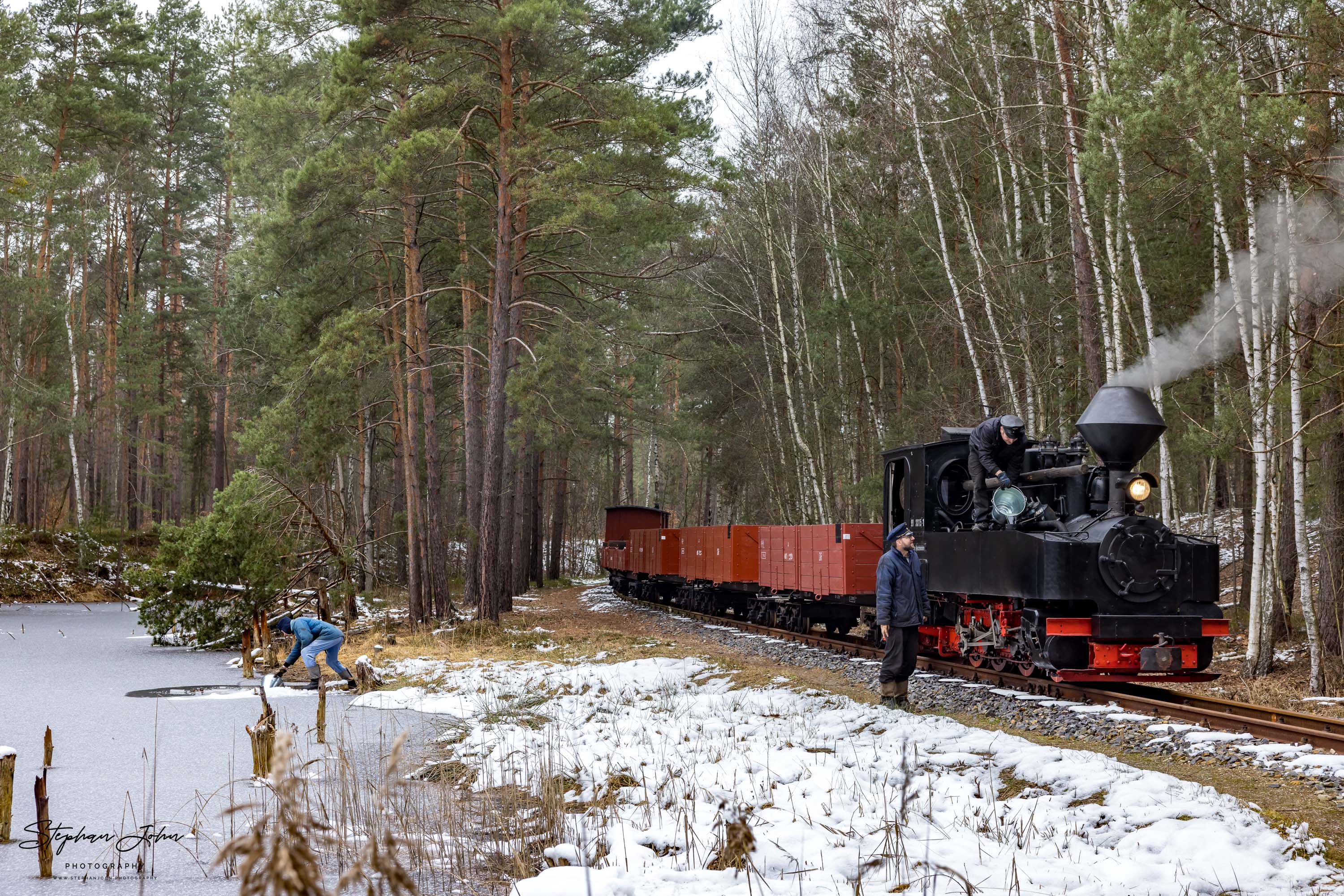 Lok 99 3315-1 mit einem Güterzug nach Weißwasser. An einem Waldteich werden mit Eimern die Wasservorräte der Lok ergänzt