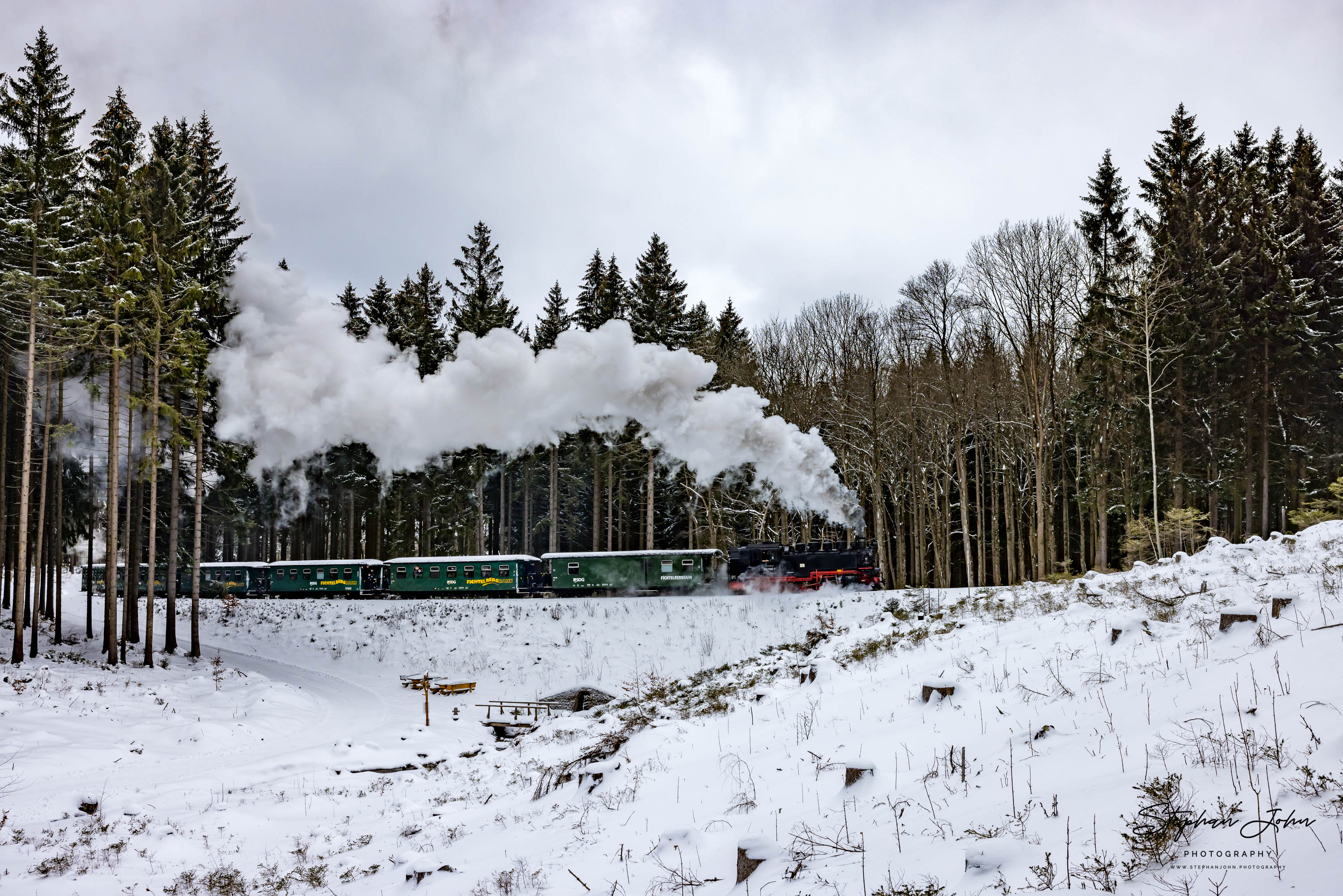 Lok 99 1785-7 hat mit P 1001 Vierenstraße verlassen und dampft durch den Wald den Berg nach Kretscham-Rothensehma hoch