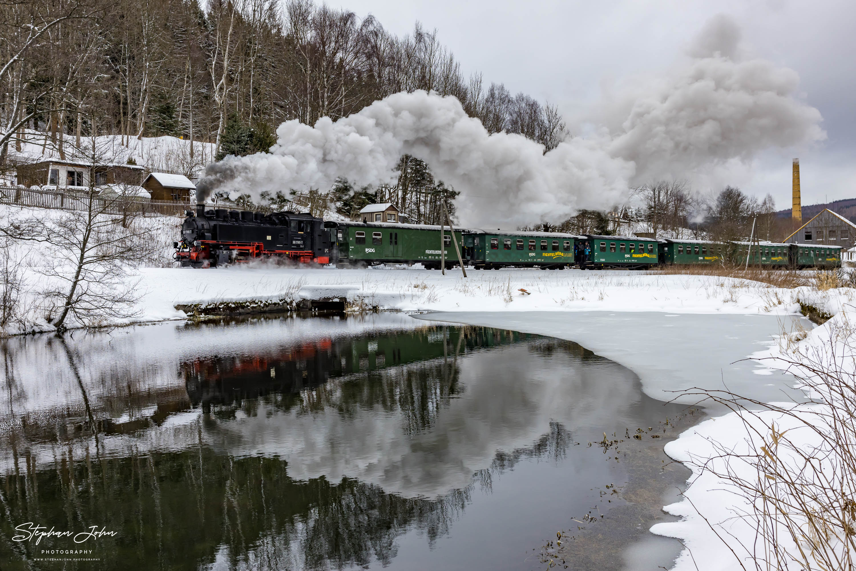 Lok 99 1785-7 hat Hammerunterwiesenthal verlassen und dampft bergauf an einem Teich vorbei weiter nach Oberwiesenthal