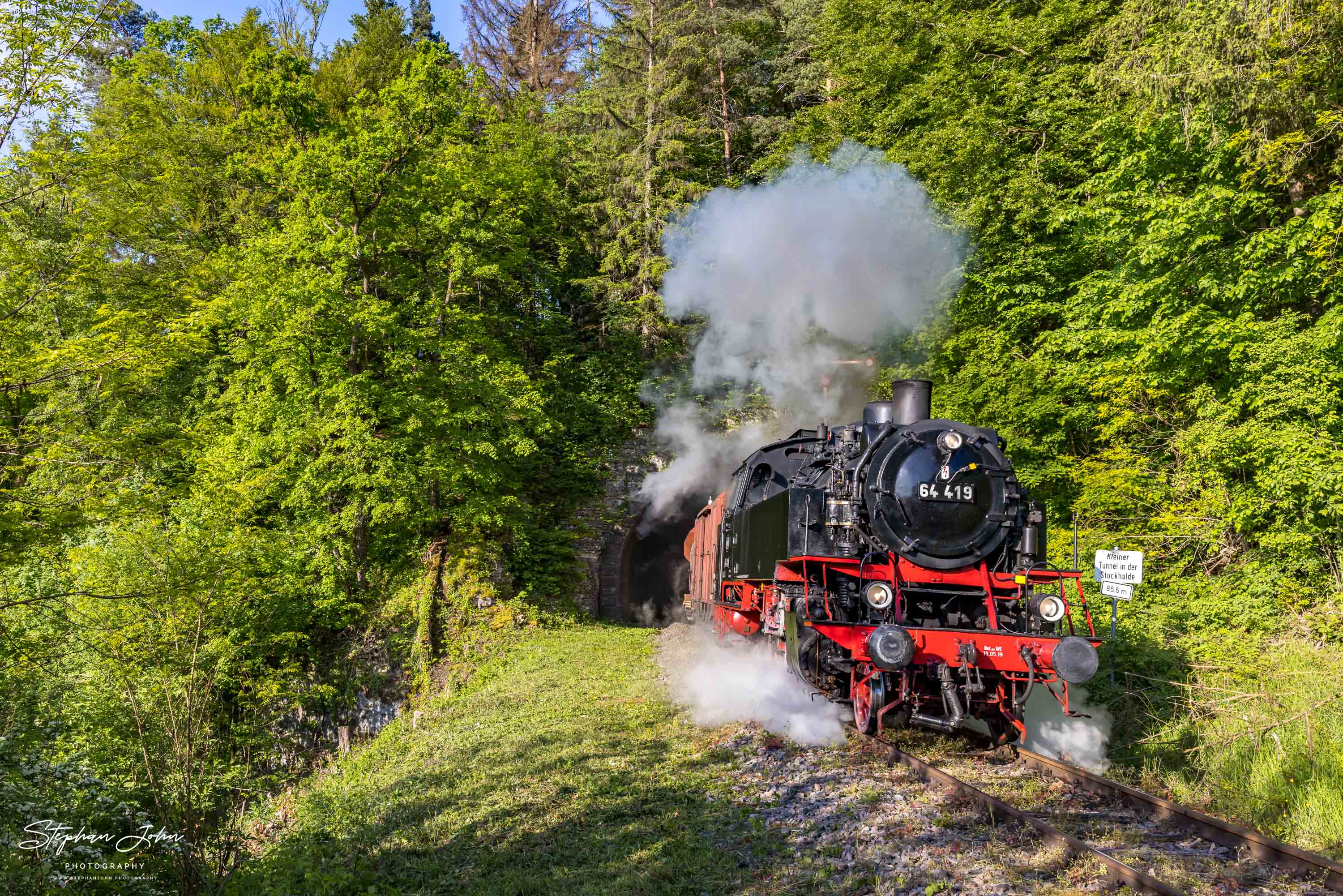 Lok 64 419 verlässt mit einem Güterzug den kleinen Stockhalde-Tunnel in Richtung Fützen