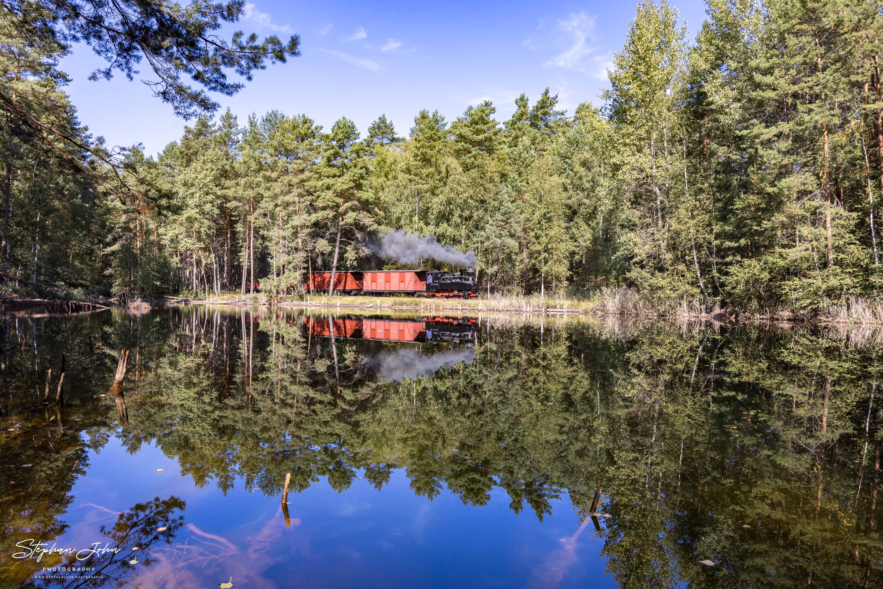 Lok 99 3315-1 mit einem GmP dampft an einem Waldteich vorbei in Richtung Weißwasser