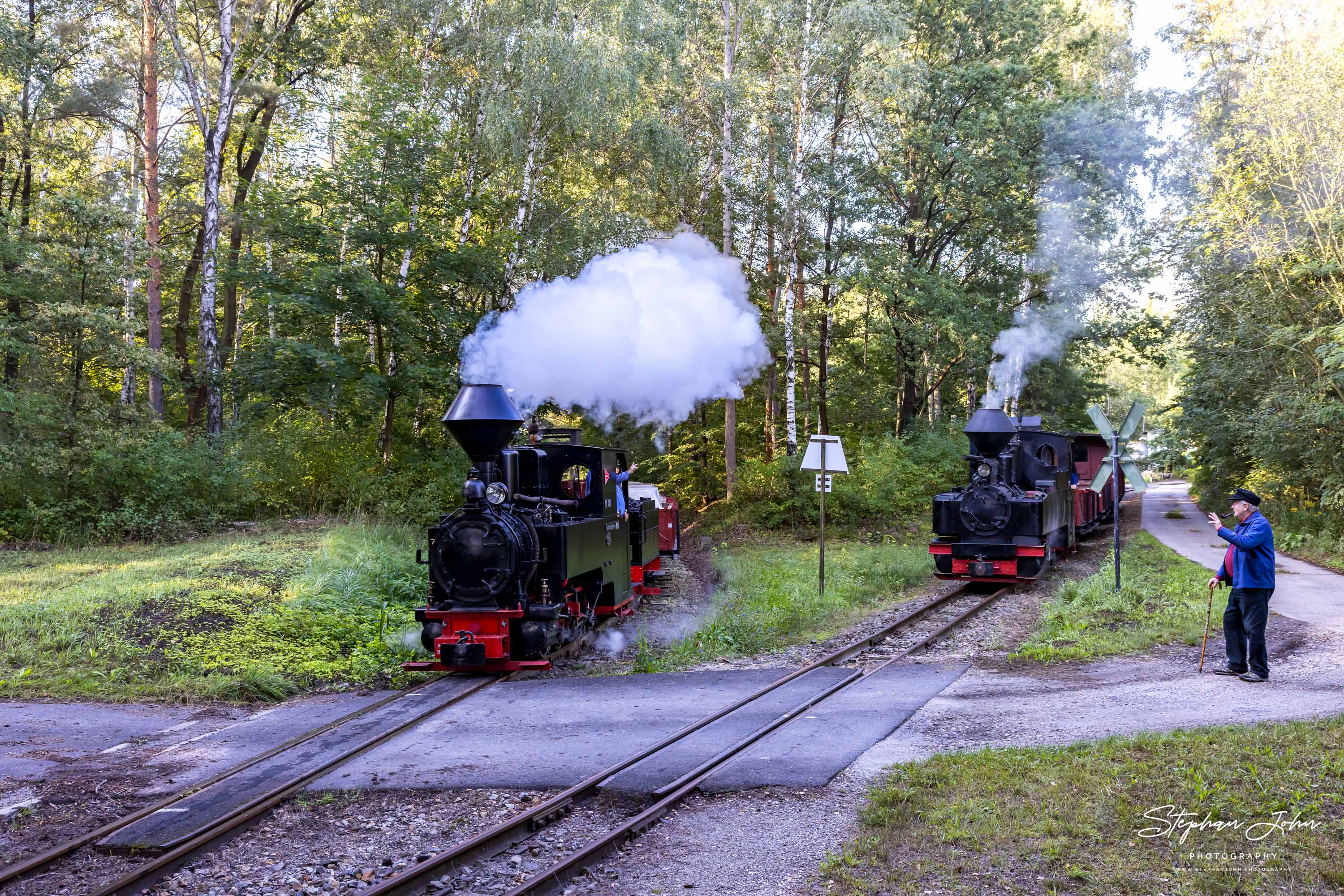 Während Lok 99 3315-1 mit einem GmP am Abzweig wartet, fährt Lok 99 3301 mit einem Güterzug nach Bad Muskau vorbei.