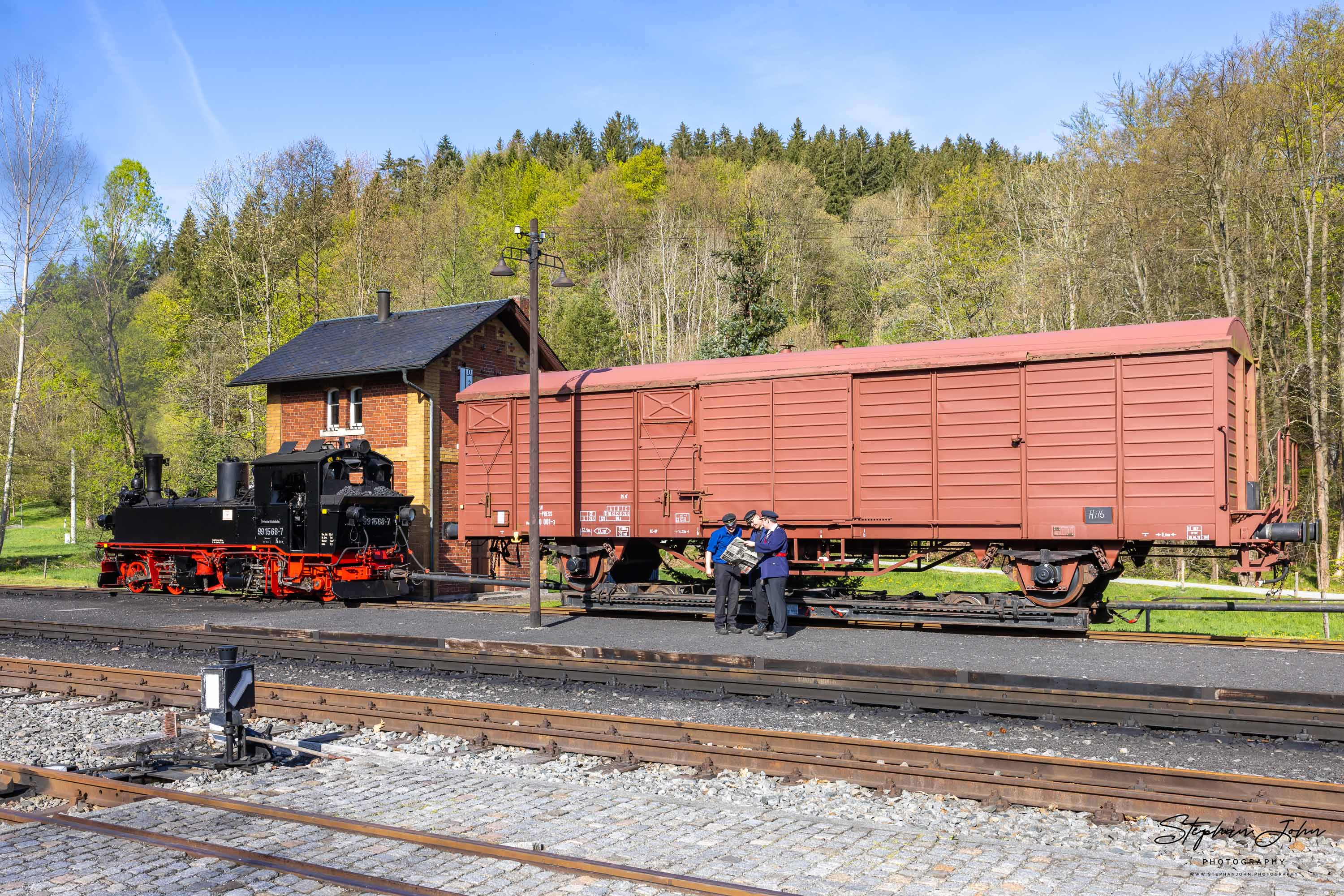 Lok 99 1568-7 steht mit einem GmP in Steinbach. Das Zugpersonal macht Pause und schaut in die aktuelle Presse.