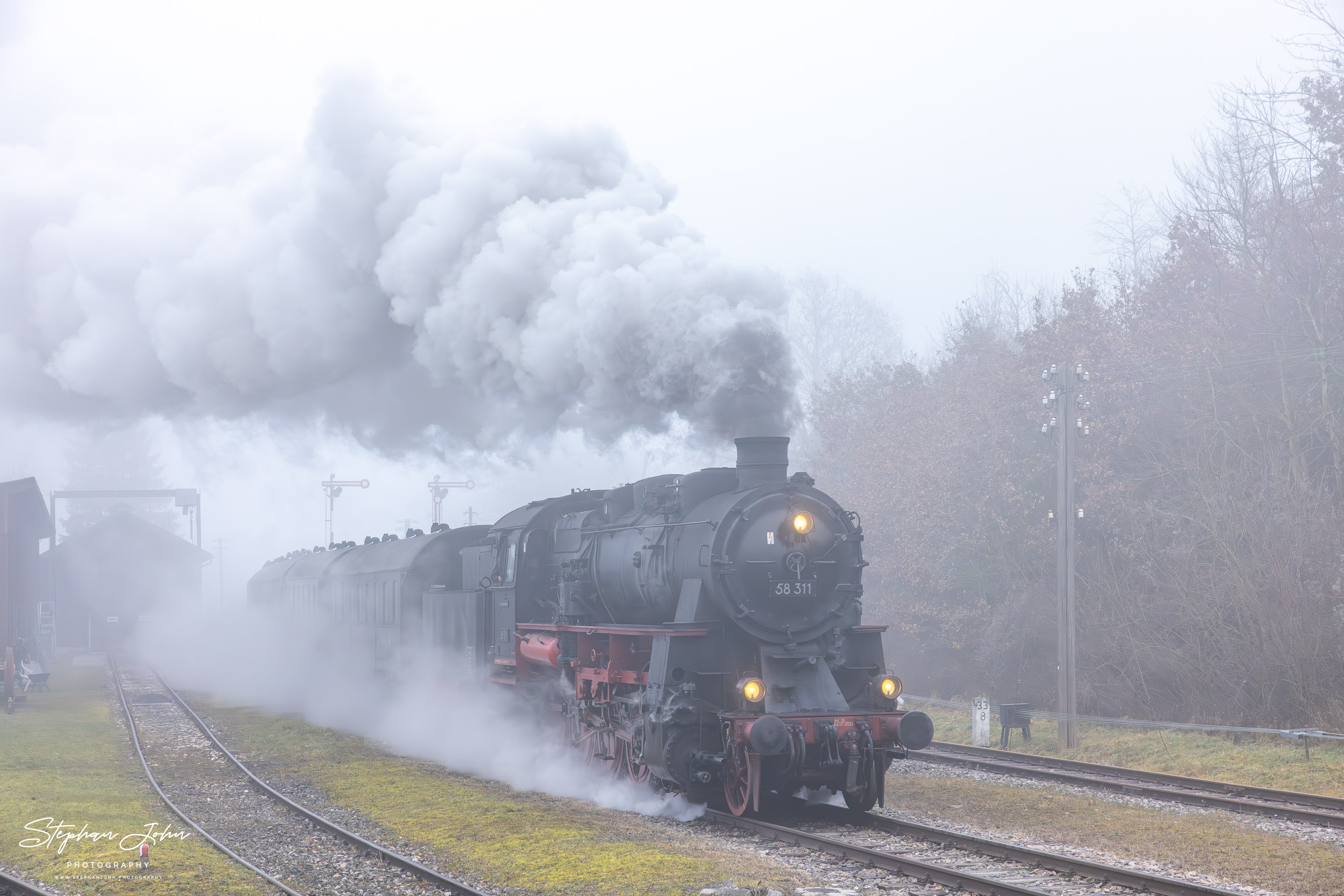 Im dichten Nebel fährt Lok 58 311 mit Zug 88237 in Fützen ein