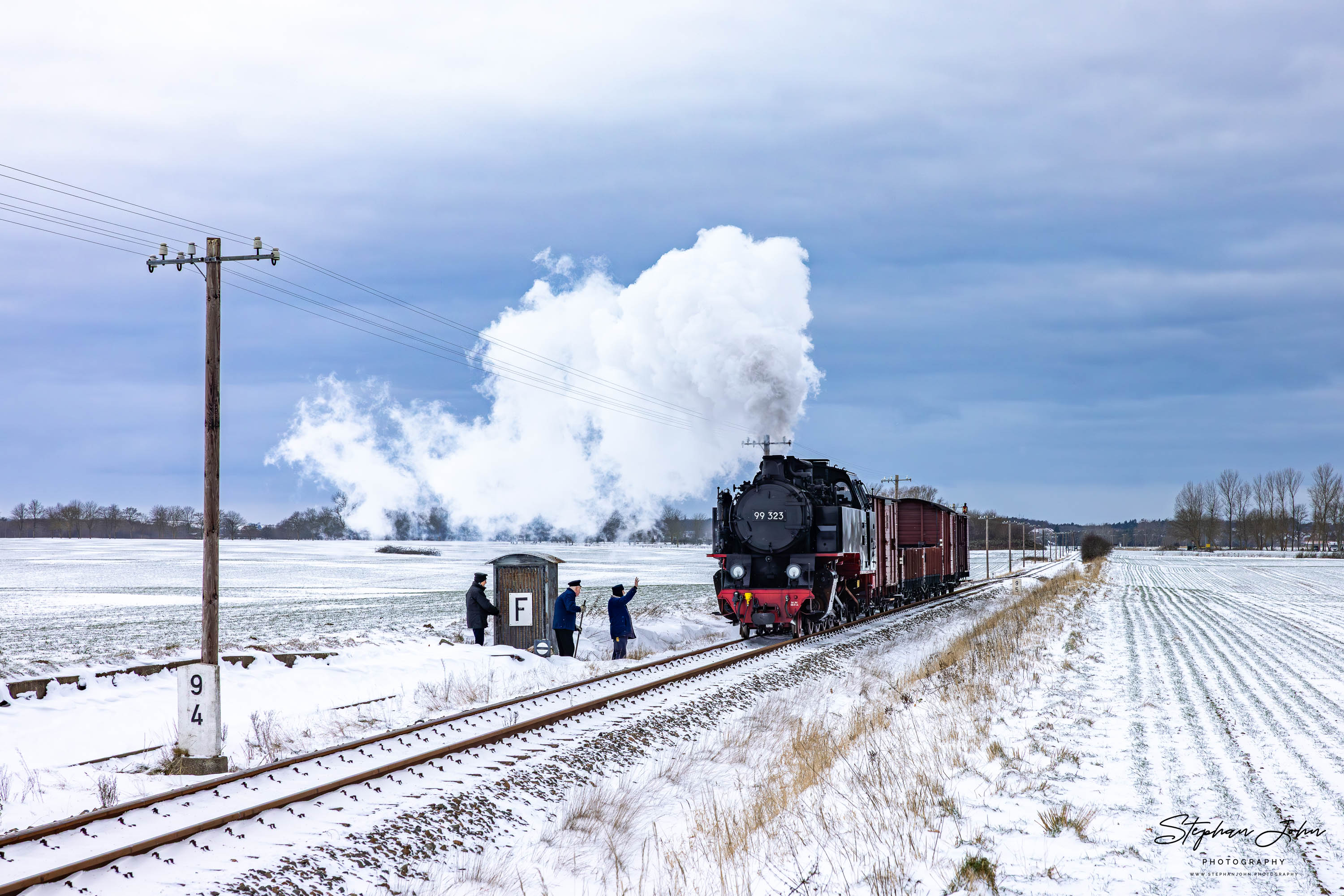 Lok 99 323 mit einem Güterzug auf dem Weg von Kühlungsborn West nach Heiligendamm passiert einen Fernsprechposten